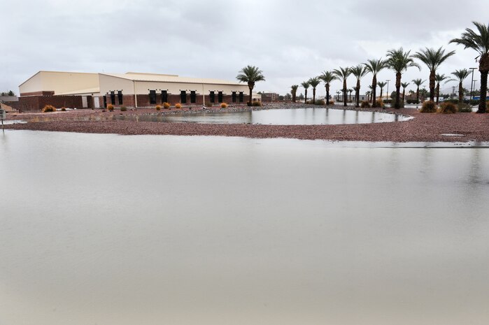NELLIS AIR FORCE BASE, Nev.--  Rainwater accumulates near the 57th Operations Support Squadron building Dec. 22. A heavy winter rainstorm slammed southern Nevada the fourth week of December. More than an inch of rain was recorded at Nellis over the week. The base populace is reminded when a flash-flood warning is issued that flooding is imminent or occurring. Those living in the affected areas should move to safety immediately. (U.S. Air Force photo by Lawrence Crespo/Released)