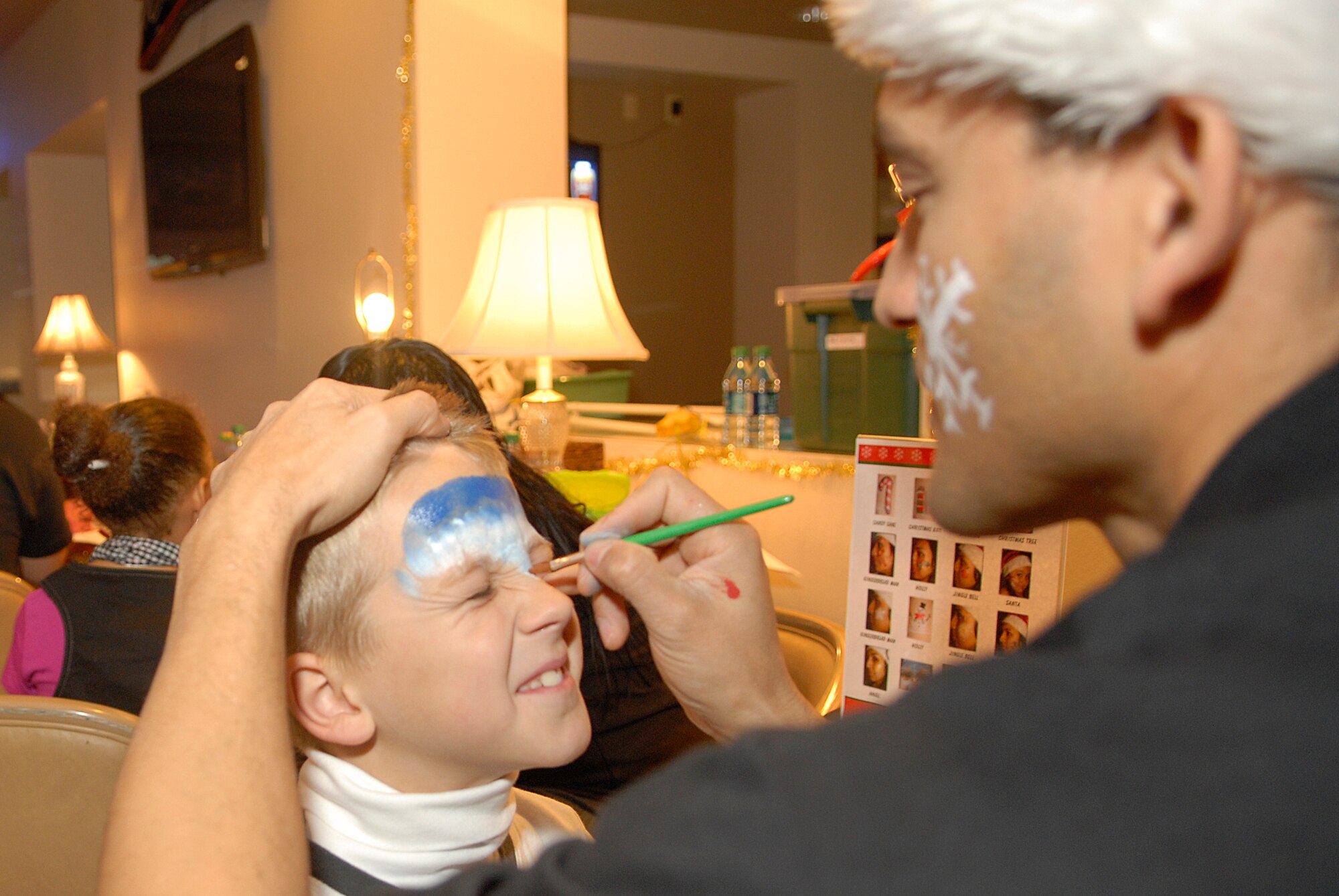 VANDENBERG AIR FORCE BASE, Calif. -- Justin Bryant, the son of Master Sgt. Alexander Bryant, 30th Logistics Readiness Squadron, gets the warrior paint at the Pacific Coast Club during the Breakfast With Santa event here Saturday, Dec. 18, 2010.  Team V families celebrated the holidays with breakfast, crafts and games.  (U.S. Air Force photo/Senior Airman Andrew Satran) 

 