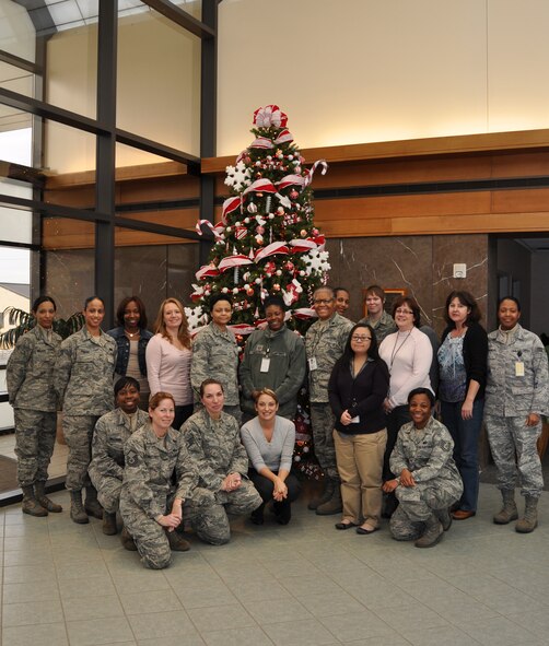 Some of the ladies of Air Force Mortuary Affairs Operations pose in the atrium following a ladies afternoon tea. Ch. (Lt. Col.) Paula Payne, invited the women to tea to pause for a moment and share their Christmas stories and family traditions with the others. (U.S. Air Force photo/Christin Michaud)