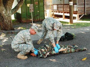 SOTO CANO AIR BASE, Honduras - Two Airmen from Joint Task Force-Bravo perform Combat Lifesaver techinques on a practice dummy during training here Dec. 14.  CLS training address proper techniques and procedures to take care of injured Soldiers, which will allow first responders to ensure maximum survivability on the battlefield.  (U.S. Air Force photo/Army PFC Kelvin Rivera)