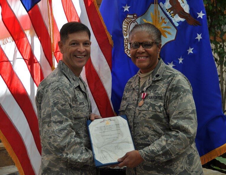 Col. Thomas C. Joyce, Air Force Mortuary Affairs Operations commander, presents the Meritorious Service Medal to Ch. (Lt. Col.) Paula Payne, deployed to the mortuary from the 253rd Combat Communications Group at Otis Air National Guard Base, Cape Cod, Mass., Dec. 21, 2010. (U.S. Air Force photo/Christin Michaud)