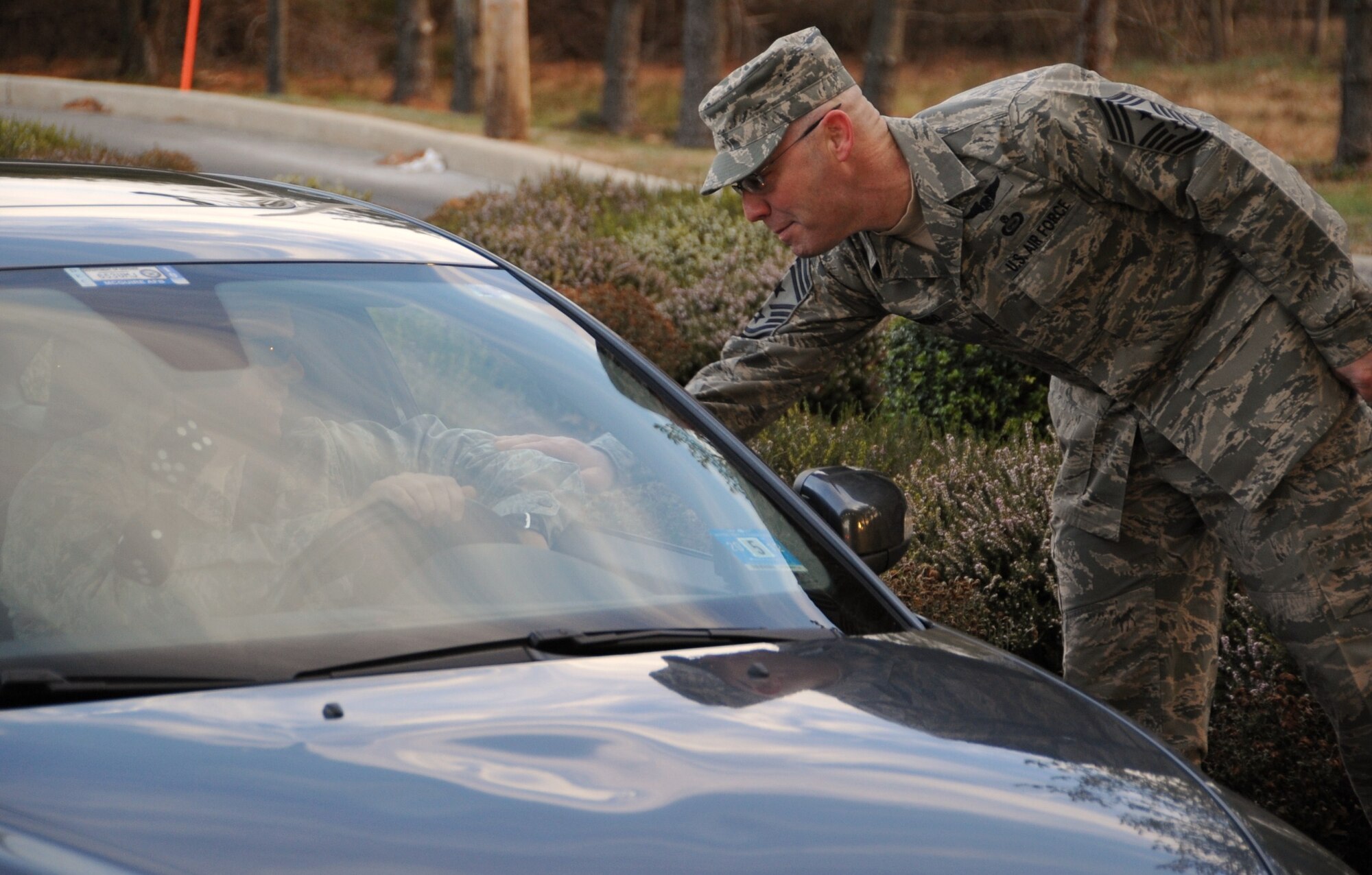 JOINT BASE MCGUIRE-DIX-LAKEHURST -- 87th Air Base Wing Command Chief Master Sgt. Warren Wofford greets Joint Base McGuire-Dix-Lakehurst community members Dec. 23 as they enter the Wrightstown Gate. The base’s senior leaders, along with gate entry personnel, check ID cards at the gate and wish all members a safe and happy holidays. (U.S Air Force photo/Airman 1st Class Dennis L. Sloan) 