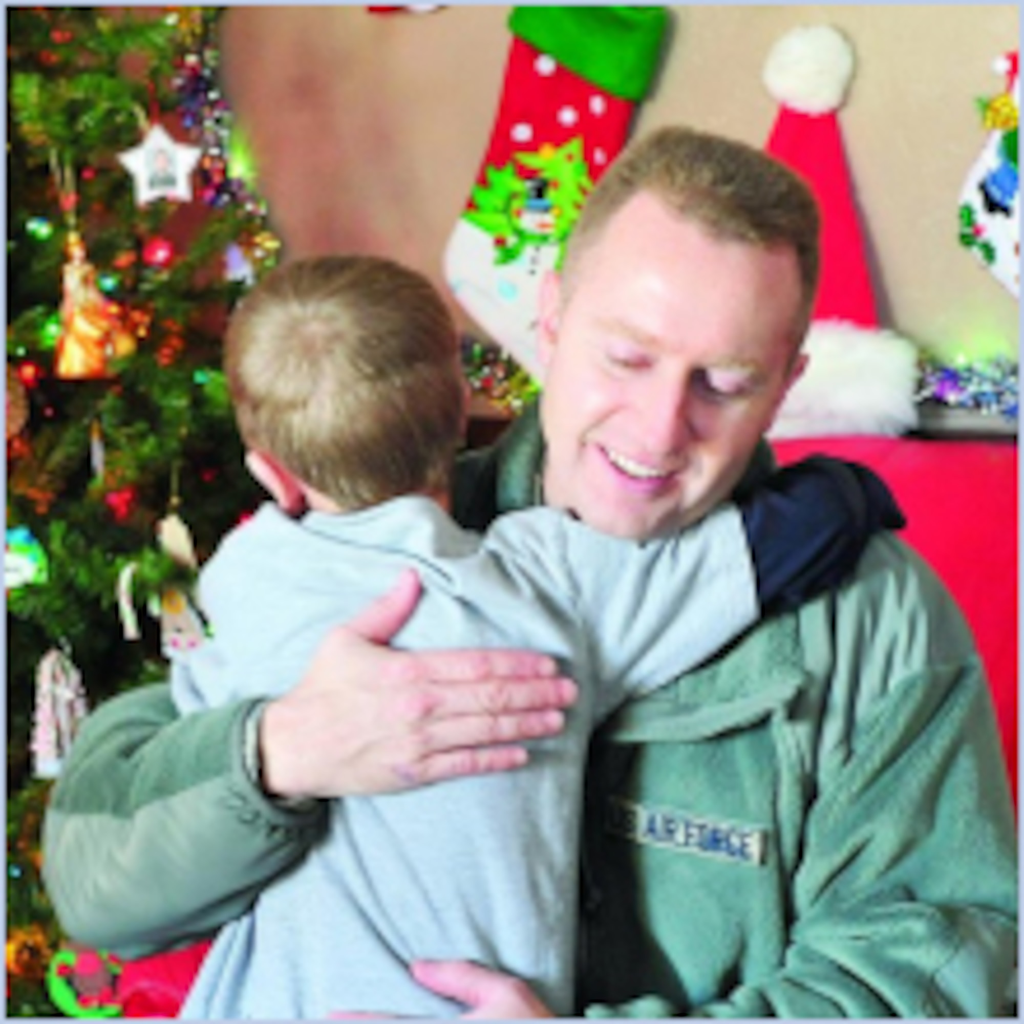 Master Sgt. Drue Titensor, 419th Aircraft Structural Maintenance supervisor, gets a hug Dec. 15 during the Utah Foster Care Foundation "Christmas Tree" event.  (U.S. Air Force photo by Kim Cook)