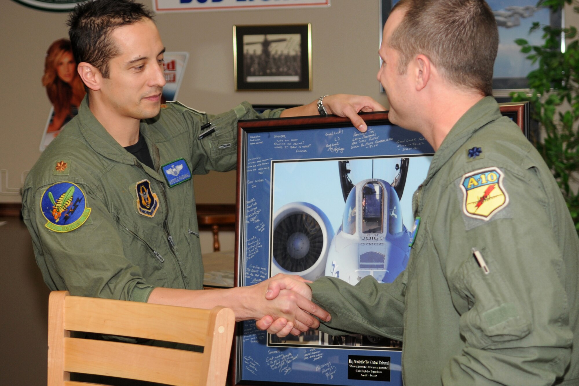 Lt. Col. James Travis, 47th Fighter Squadron commander, presents a going-away picture to Maj. Aristotle Rabanal, 47th FS pilot. Rabanal flew his last sortie with the 47th FS on Dec 21, 2010, 917th Wing, Barksdale Air Force Base, La. (U.S. Air Force/MSgt Greg Steele)