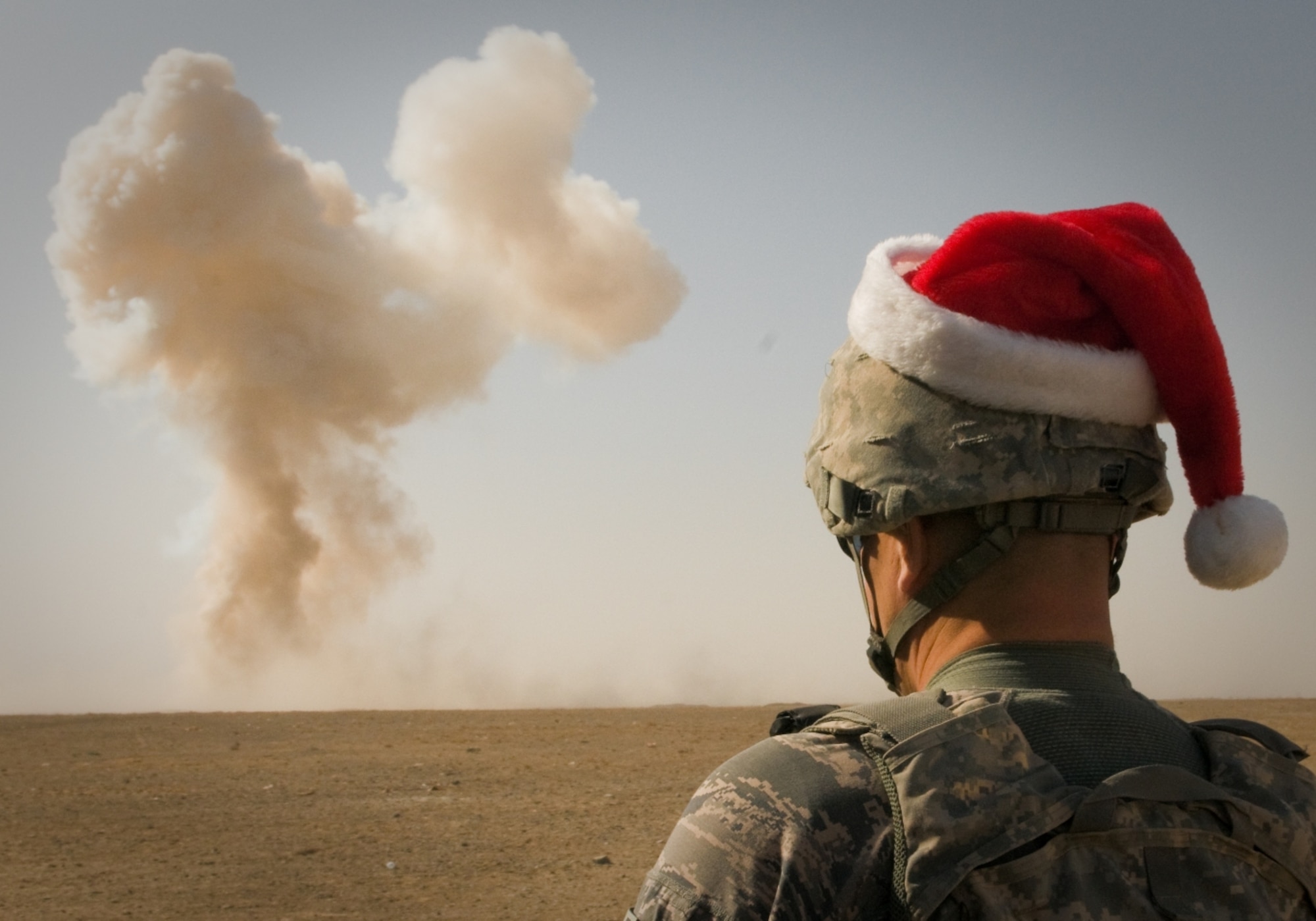 U.S. Air Force Tech. Sgt. Robert L. Woods, 466th Air Expeditionary Group, Explosive Ordnance Disposal team leader, detonates home-made explosives and expired ammunition while dressed in a Santa hat, Dec. 22, outside Kandahar Air Field, Afghanistan. His home unit is the 123rd Airlift Wing in Louisville, Ky. (U.S. Army photo by Spc. Edward Garibay / released)