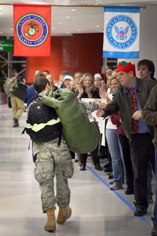 Operation Welcome Home volunteers greet a U.S. airman upon his arrival at the Baltimore-Washington International Thurgood Marshall Airport, Md., Dec. 22, 2010. The airman was among 260 U.S. troops returning home for the holidays after months of service abroad, including deployments to Iraq and Afghanistan.