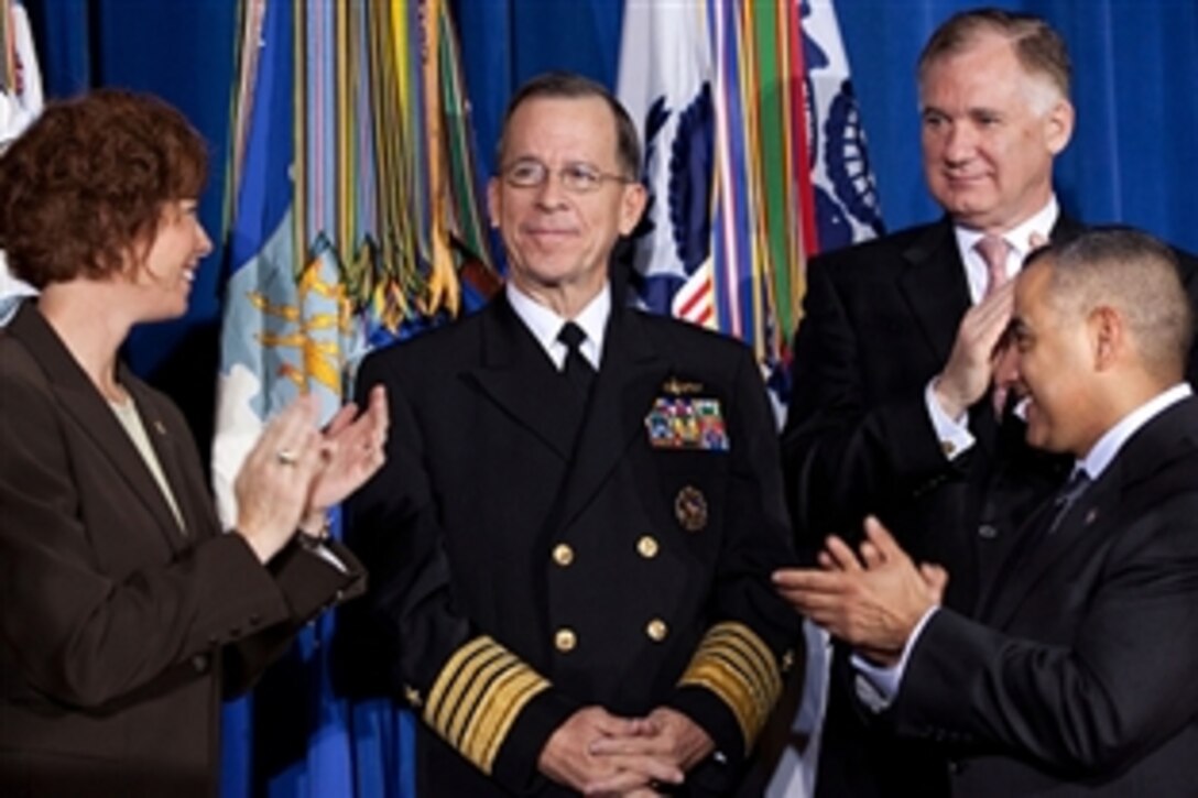 With Deputy Defense Secretary William J. Lynn III to his left, Chairman of the Joint Chiefs of Staff U.S. Navy Adm. Mike Mullen is acknowledged before President Barack Obama signs the Don't Ask, Don't Tell Repeal Act of 2010 during a ceremony at the Interior Department in Washington, D.C., Dec. 22, 2010.