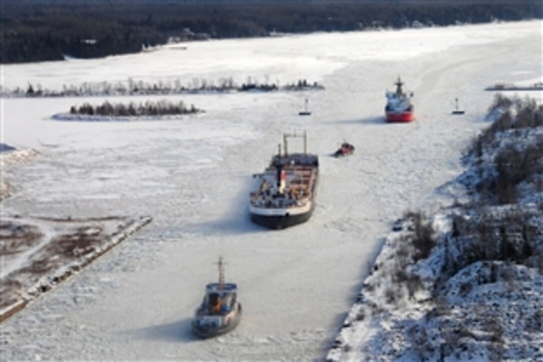 U.S. Coast Guard Cutters Biscayne Bay, bottom, and Mackinaw, top, break ice in the lower end of the Rock Cut in the St. Marys River in Mich., Dec. 22, 2010. The cutters were called to break ice in the area after the freighter Cedar Glen, center, became beset by ice the previous day. Cedar Glen was beset for approximately 19 hours before the Coast Guard vessels were able to free it.