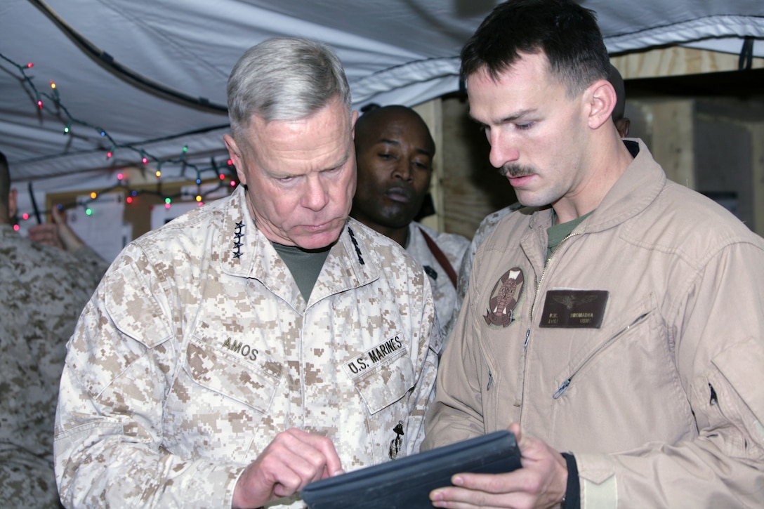 First Lt. Russell W. Hromadka, a UH-1Y Huey pilot with Marine Light Attack Helicopter Squadron 169, 3rd Marine Aircraft Wing (Forward), gives the commandant of Marine Corps, Gen. James F. Amos, a demonstration of how to utilize the Geographical Reference Group on the iPad, Dec. 23.  Amos, along with Sgt. Maj. Carlton W. Kent, sergeant major of the Marine Corps, visited several bases throughout Afghanistan to wish the troops merry Christmas.