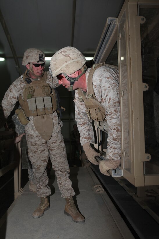 Captain Devin R. Blowes, left, commanding officer, assists Gunnery Sgt. Issac D. Sweeton, company gunnery sergeant, Company L, Battalion Landing Team 3/8, 26th Marine Expeditionary Unit, out of the gunners hatch of the Mine Resistant Ambush Protected (MRAP) vehicle egress trainer aboard Camp Buehring, Kuwait, Dec. 24, 2010. Elements of 26th MEU disembarked the ships of Kearsarge Amphibious Ready Group to conduct sustainment training in various Middle Eastern and African countries. (Official USMC photo by Sgt. Jesse J. Johnson/ Released) ::r::::n::