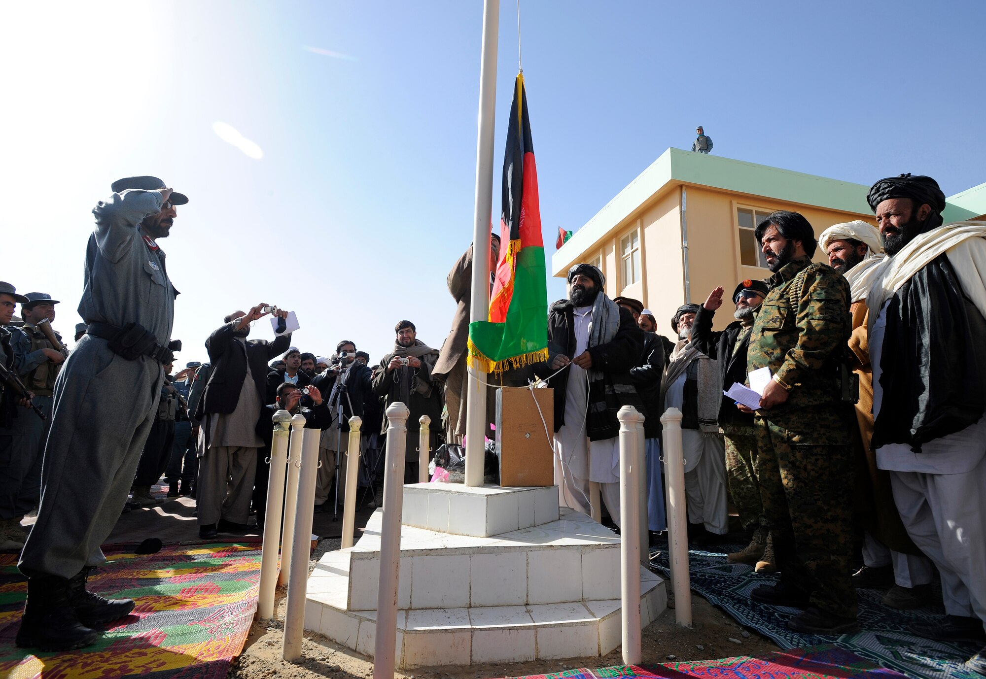Zabul Provincial Gov. Ashraf Naseri raises the Afghan flag during the opening of the Shajoy District Center, Dec. 23. Provincial leaders were on hand to open the district center and speak to the more than 90 local villagers in attendance. (U.S. Air Force photo/Staff Sgt. Brian Ferguson) (Released).