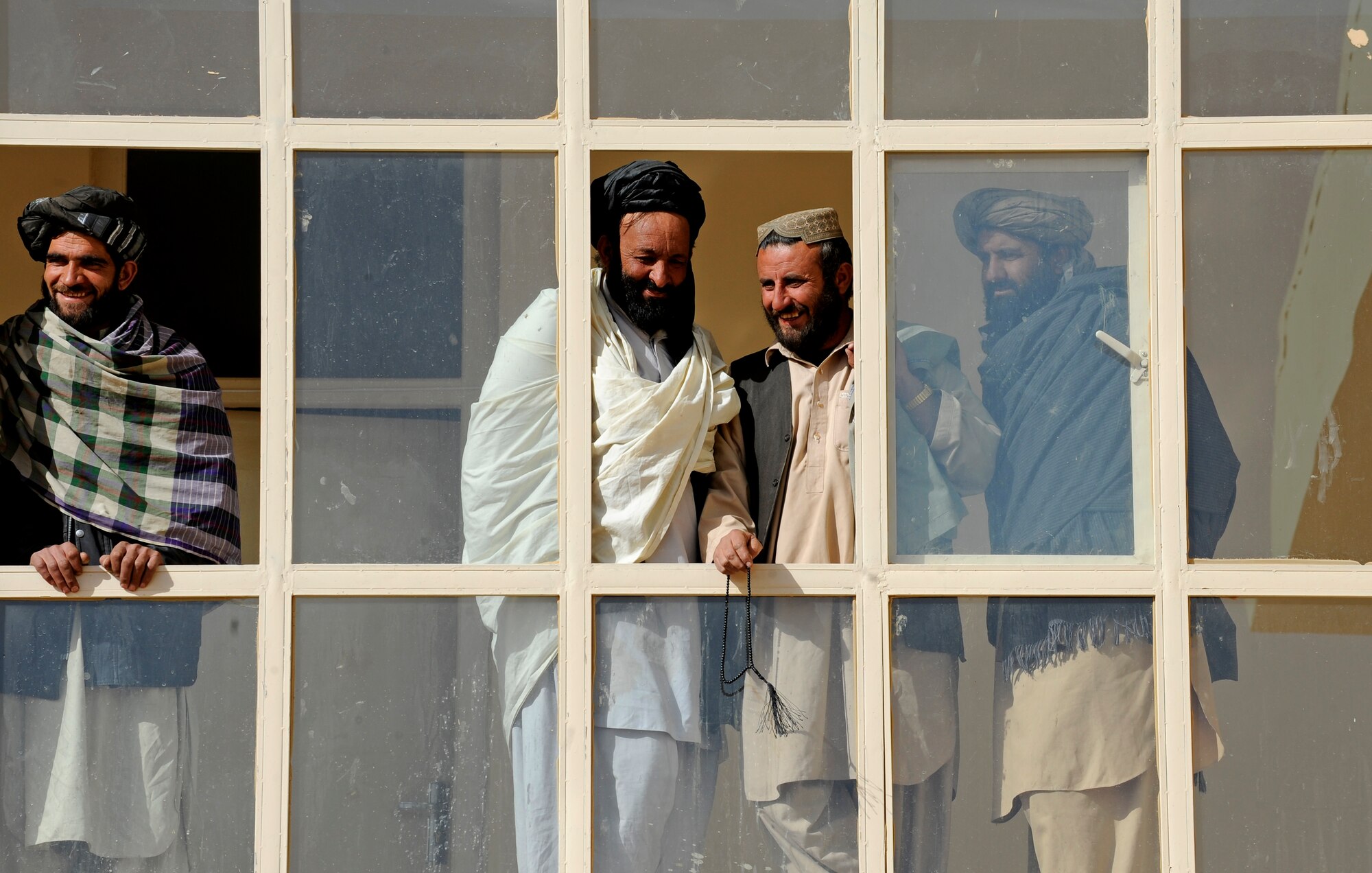 Afghans look on from the second floor of the new Shajoy District Center during a ribbon cutting ceremony, Dec. 23. Provincial leaders were on hand to open the district center and speak to the more than 90 local villagers in attendance. (U.S. Air Force photo/Staff Sgt. Brian Ferguson) (Released).