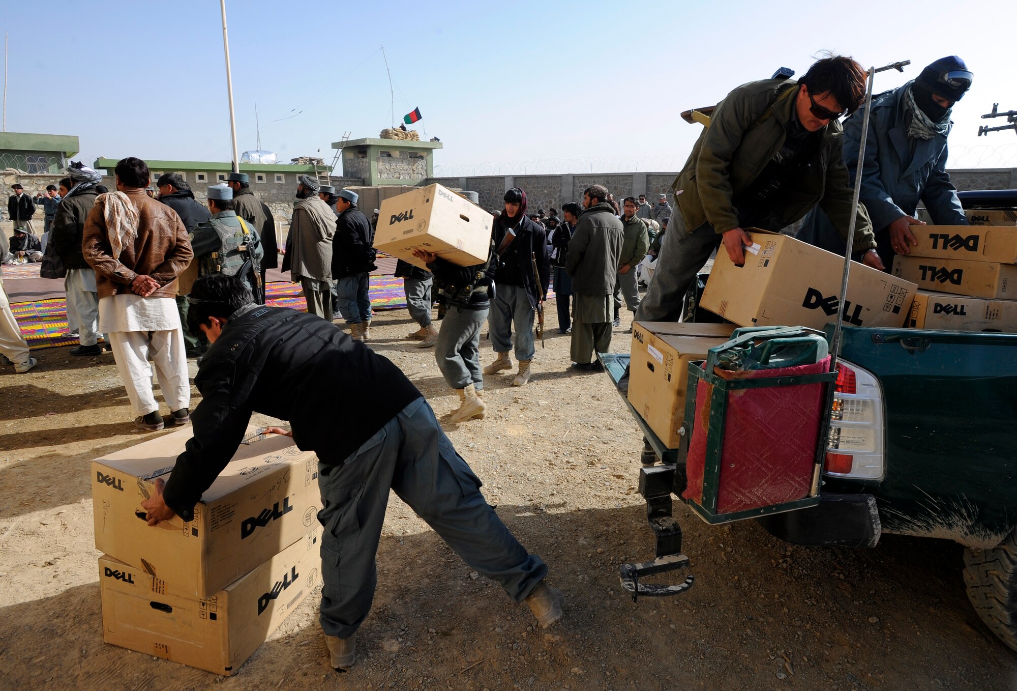 Afghan National Police officers unload computers for the new Shajoy District Center before the opening ceremonies, Dec. 23. Provincial leaders were on hand to open the district center and speak to the more than 90 local villagers in attendance. (U.S. Air Force photo/Staff Sgt. Brian Ferguson) (Released).