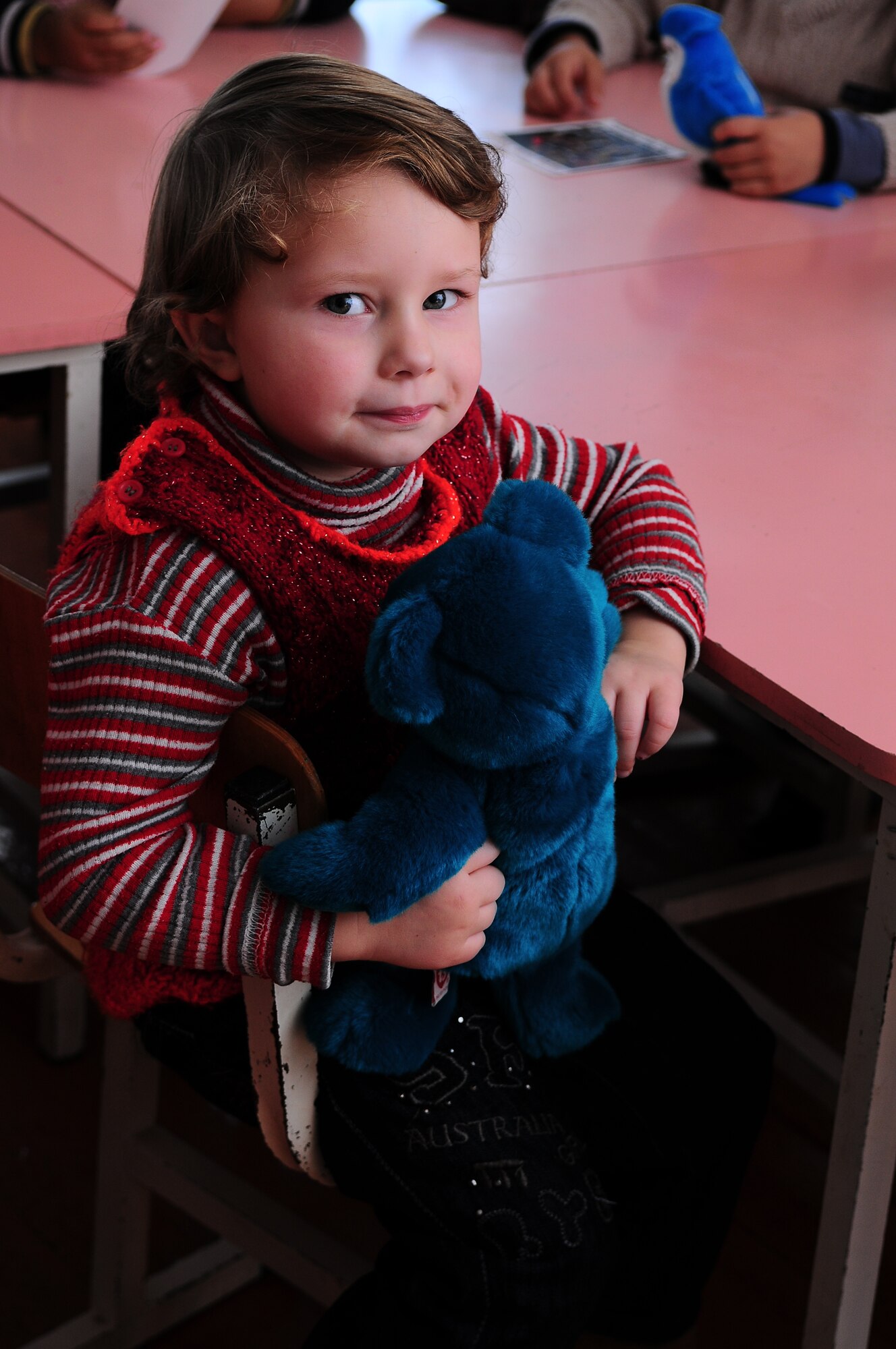 TRANSIT CENTER AT MANAS, Kyrgyzstan - A child from a local school poses for the camera as New England Patriot Cheerleaders entertained and provided gifts as part of an Armed Forces Entertainment tour Dec. 23.  The cheerleaders took a cultural tour of Bishkek, performed for deployed military members and toured the Transit Center at Manas. (U.S. Air Force photo/Staff Sgt. Stacy Moless)