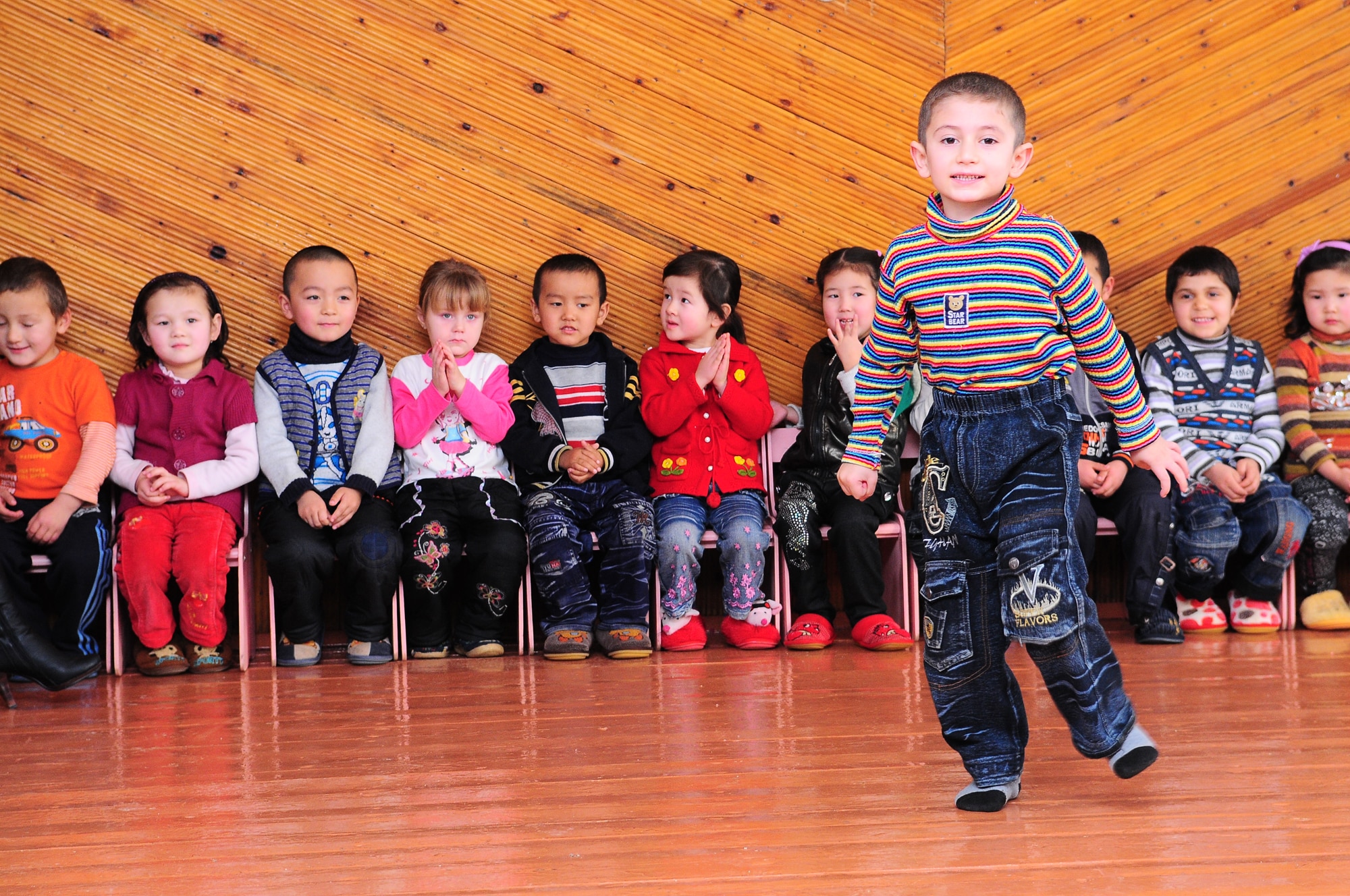 TRANSIT CENTER AT MANAS, Kyrgyzstan - A child from a local school performs for the New England Patriot Cheerleaders during their visit as part of an Armed Forces Entertainment tour Dec. 23.  The cheerleaders took a cultural tour of Bishkek, performed for deployed military members and toured the Transit Center at Manas. (U.S. Air Force photo/Staff Sgt. Stacy Moless)