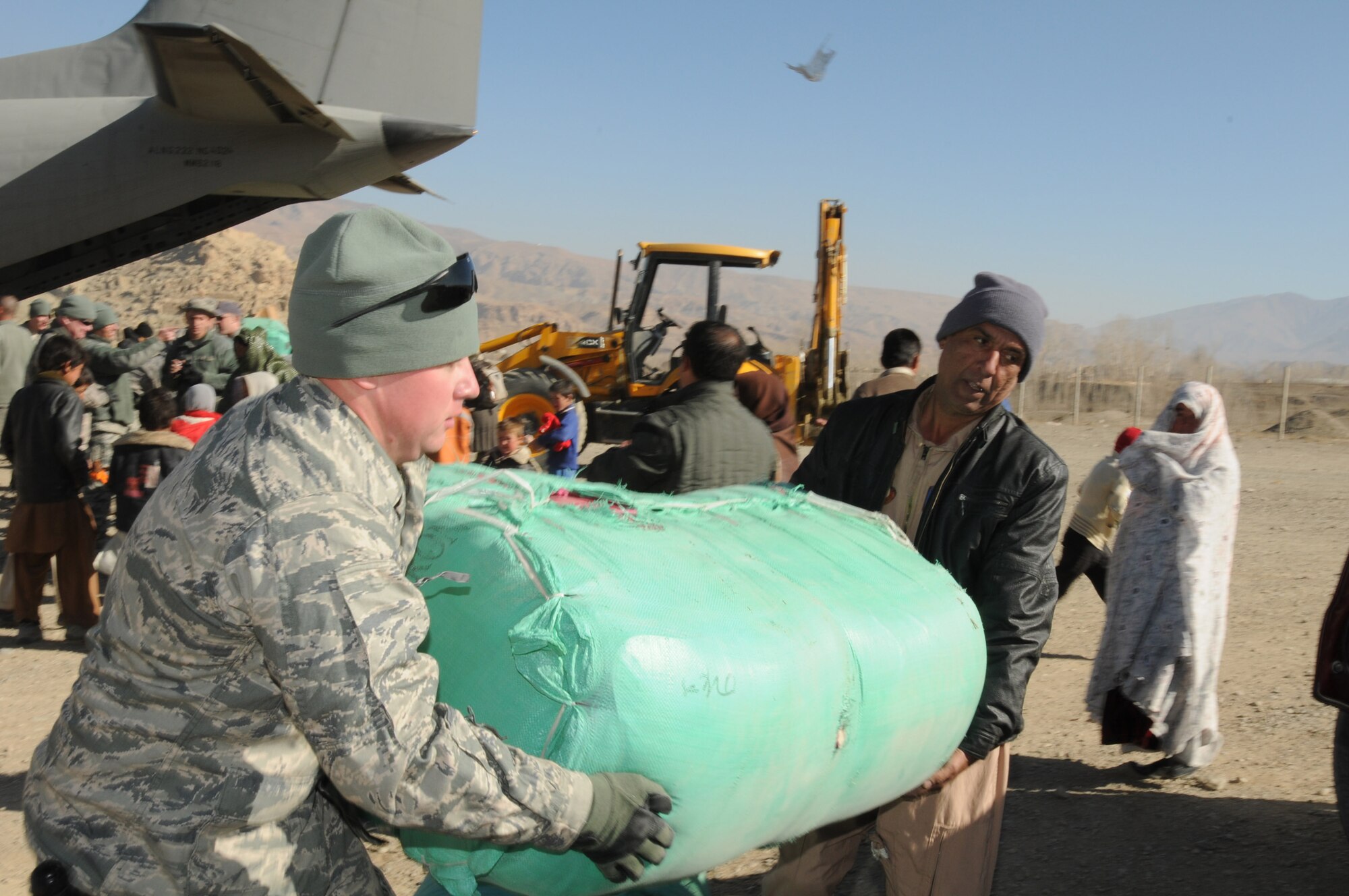 BAMIYAN, Afghanistan -- Afghan Air Force and NATO Air Training Command-Afghanistan troops deliver over 3,600 pounds of supplies as part of a humanitarian assistance mission in Bamiyan province. (U.S. Navy photo by Mass Communications Specialist 2nd Class Vladimir Potapenko/RELEASED)