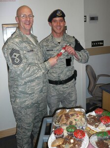 OFFUTT AIR FORCE BASE, Neb. - Chief Master Sgt. Thomas Narofsky, U.S. Strategic Command command chief, greets Airman 1st Class Daniel Windham, 55th Security Forces Squadron, with some holiday treats Dec. 24.  STRATCOM&#039;s senior leaders visited various work centers to present cookies, candy and snacks and thank approximately 100 military and civilian workers for their service during the holidays.  STRATCOM&#039;s Top 3 organization sponsored the event.