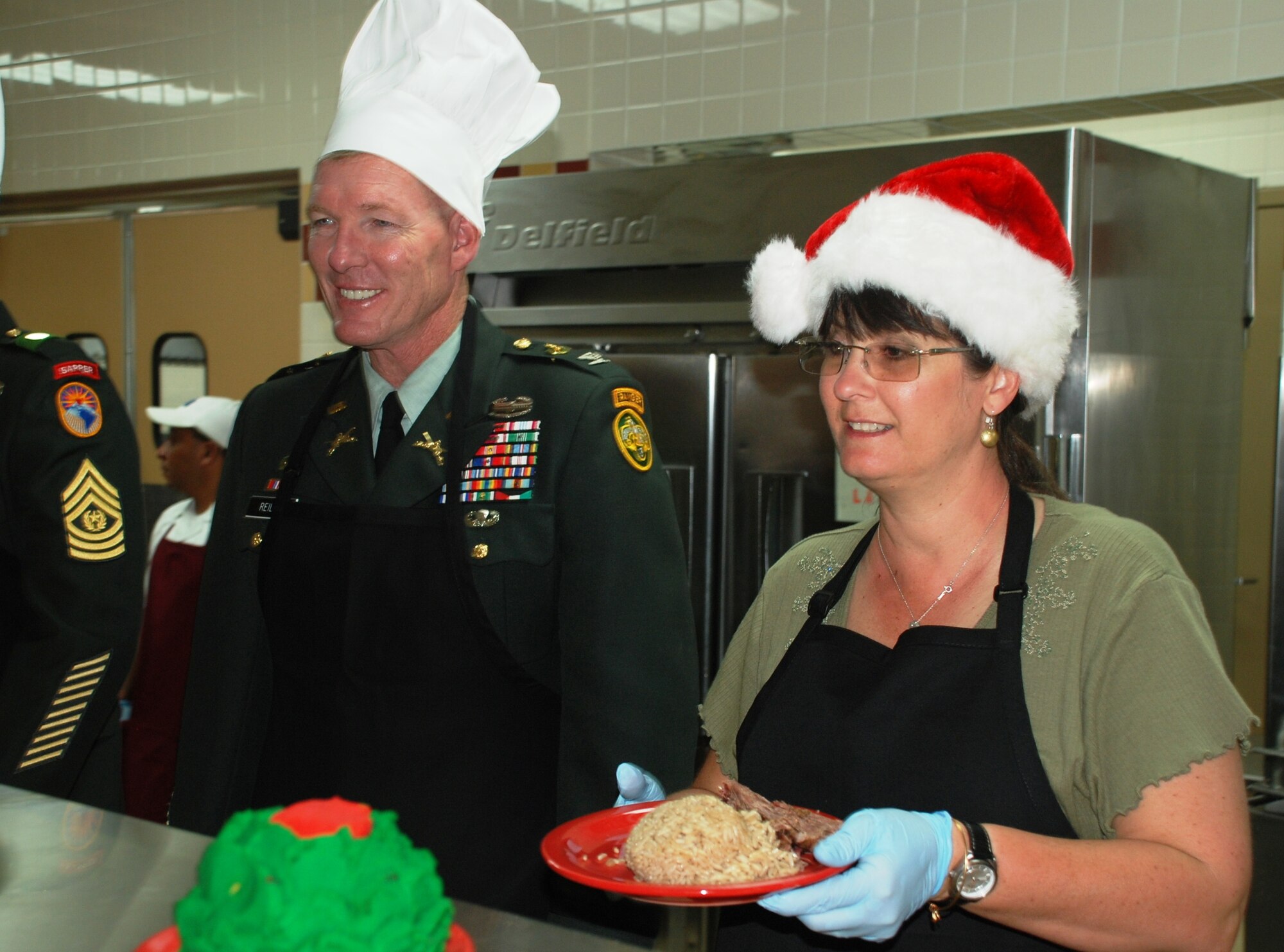 SOTO CANO AIR BASE, Honduras -  Col. Greg Reilly, Joint Task Force-Bravo commander, and Mrs. Lisa Reilly serve a homestyle Christmas lunch to the troops here Dec. 25.  (U.S. Air Force photo/Capt. John T. Stamm)
