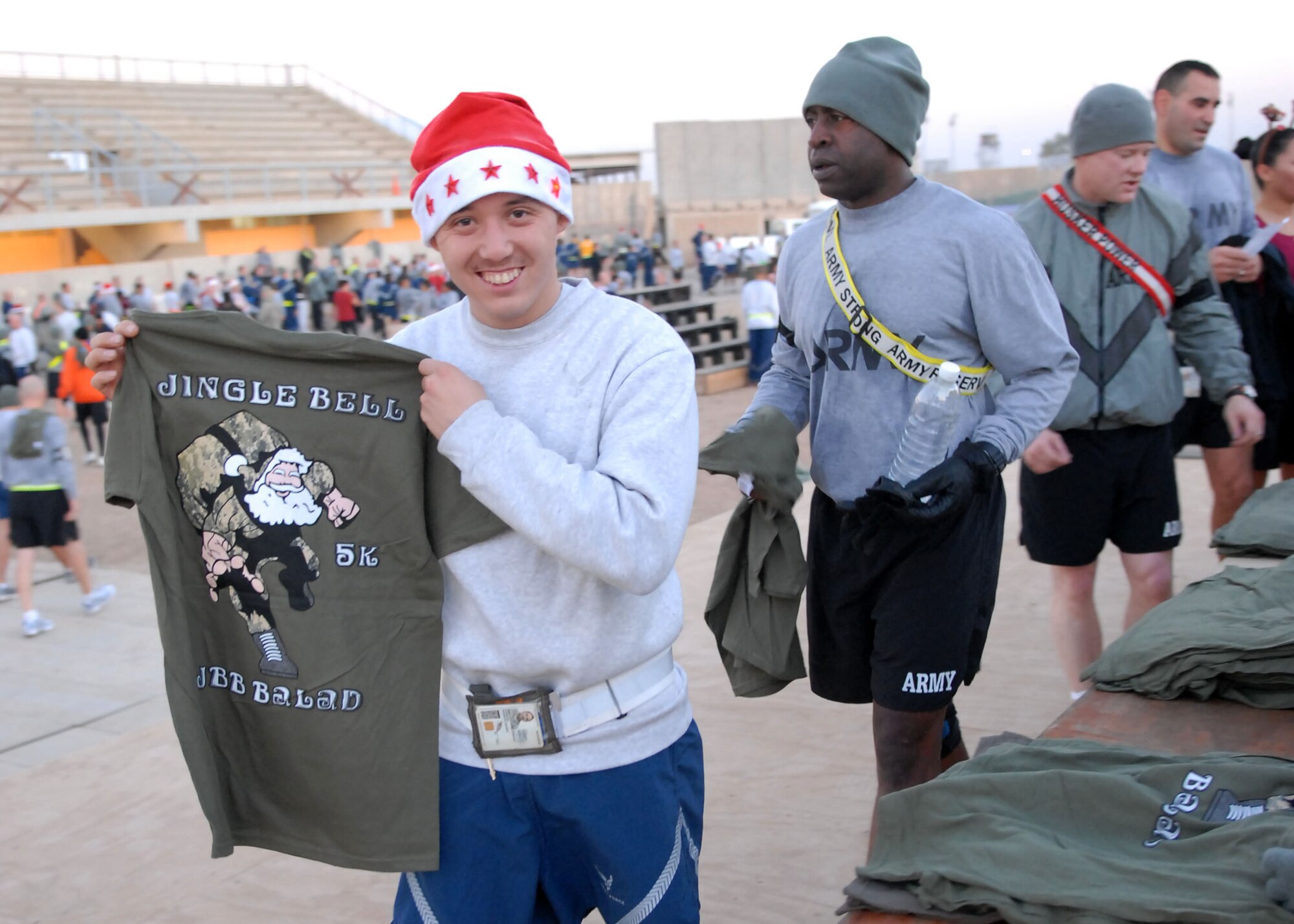 JOINT BASE BALAD, Iraq – Staff Sgt. Kennith Samson, 332nd Expeditionary Maintenance Squadron aircraft ground equipment journeyman, proudly displays his prize after completing his first 5K with a time of 25:25, Christmas morning. More than 400 Soldiers, Sailors, Airmen and Marines participated in the Jingle Bell 5K run at Holt Stadium. Sergeant Samson is a native of Seattle and is deployed from Misawa Air Base, Japan. (U.S. Air Force photo/ Senior Airman Tong Duong)
