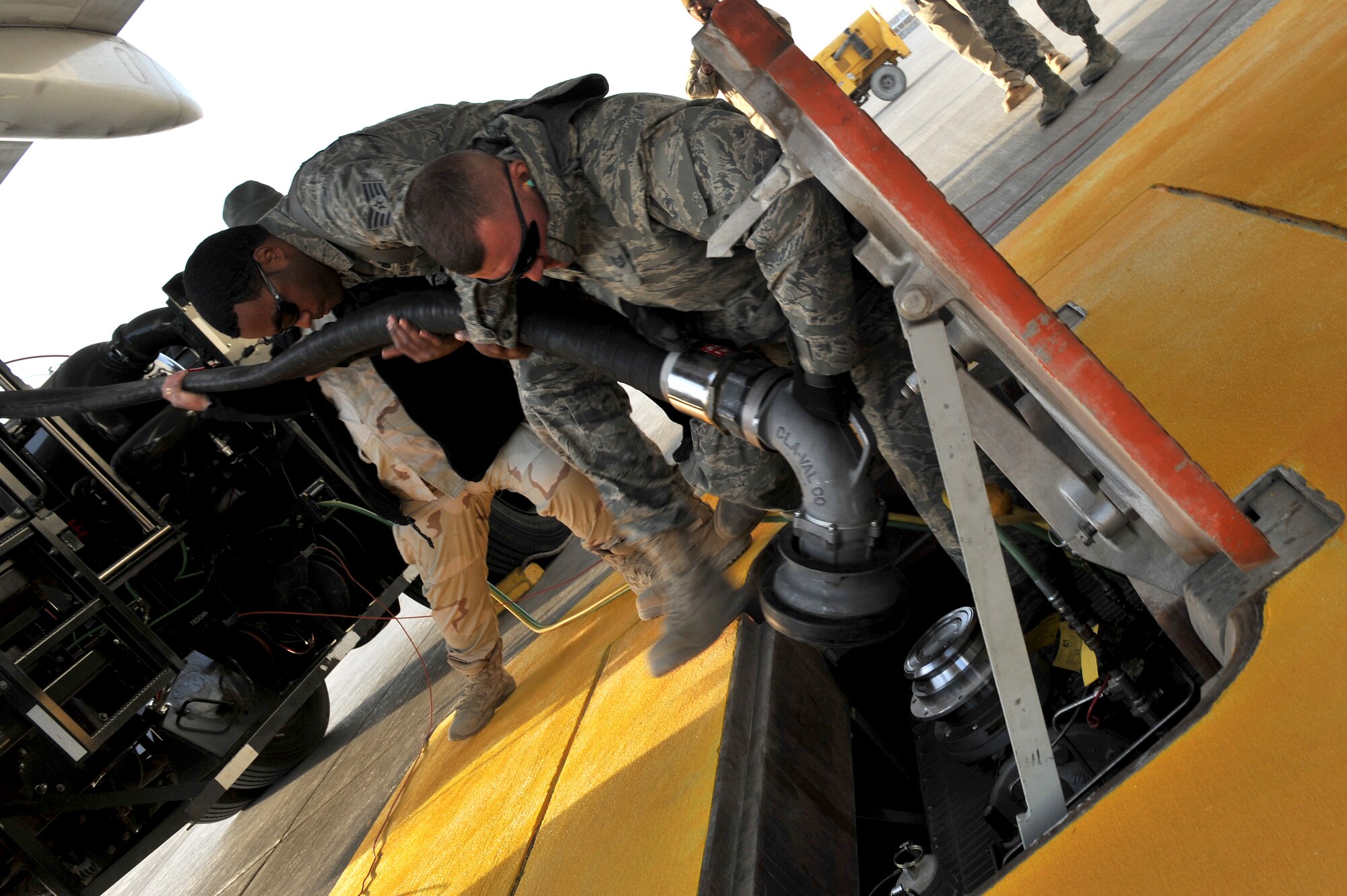 Tech. Sgt. Jeremy Whitworth and Staff Sgt. Aaron Simmons, both from the 455th Expeditionary Logistics Readiness Squadron, pull a hydrant hose from a new R-12 hydrant servicing vehicle at Bagram Airfield, Afghanistan, Dec. 21, 2010. The squadron recently received five HSVs and completed the new Type III constant pressure system became fully operational and will significantly increase refueling capabilities. Sergeant Whitworth is a native from Calif., and Sergeant Simmons is a native from Vt. (DoD photo by U.S. Air Force Senior Airman Sheila deVera/RELEASED)