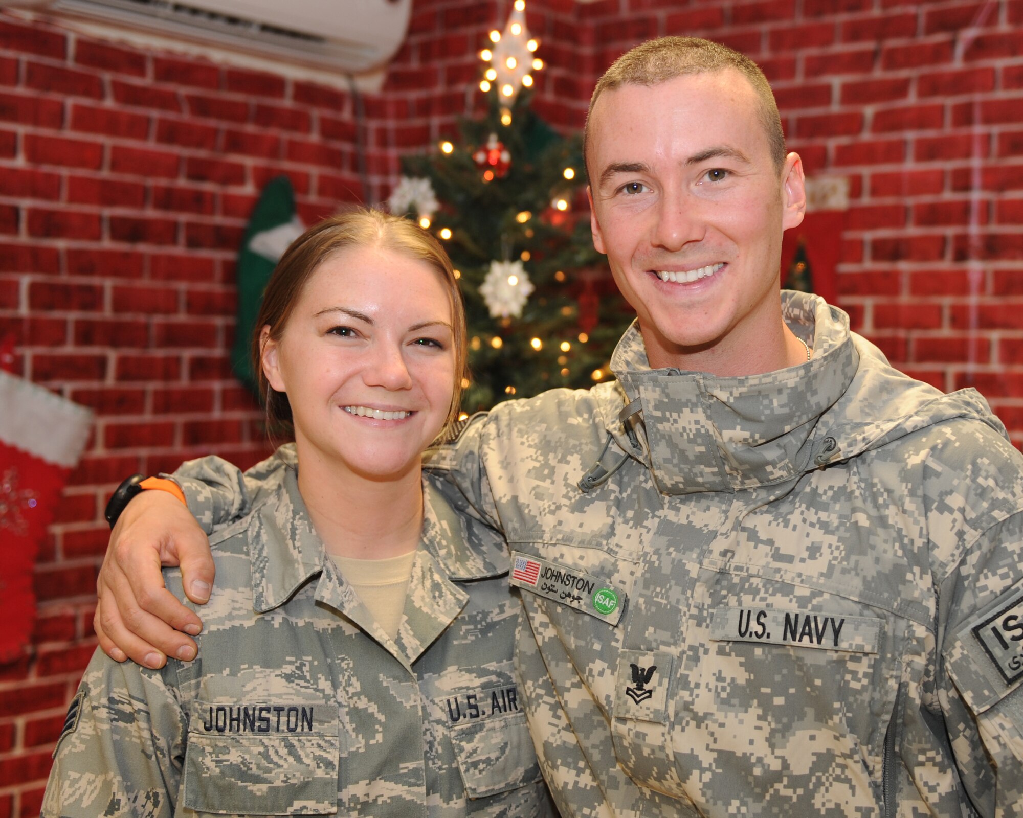 Senior Airman Emilie Johnston and Petty Officer 2nd Class Jason Johnston pose for a photograph in front of a Christmas tree Dec. 24, 2010, at Kandahar Airfield, Afghanistan. Petty Officer Johnston flew into KAF to spend Christmas with his sister Airman Johnston, a medical technician with the 451st Air Expeditionary Squadron. Petty Officer Johnston is a mass communication specialist assigned to Regional Command North at Camp Marmal in Mazar-e-Sharif, Afghanistan. (U.S. Air Force photo by Tech. Sgt. Chad Chisholm/Released)   