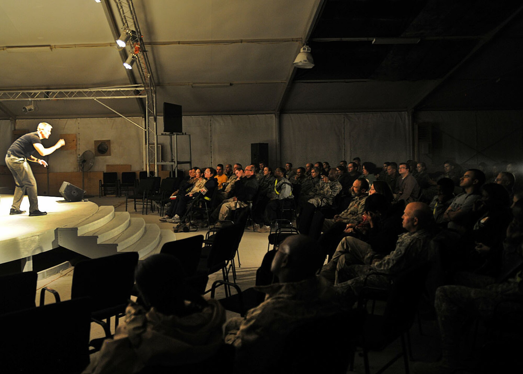 A crowd of nearly 100 people watch as U.S. Air Force Maj. Kevin Whaley, an intelligence, surveillance and reconnaissance collection manager for Regional Command-South, performs Charles Dickens? ?A Christmas Carol? at Kandahar Airfield, Afghanistan, Dec. 19. Major Whaley adapted the play to include references understood by deployed members, e.g., replacing the monetary denotations such as farthing and pence with Eagle Cash Card. (U.S. Air Force photo by Senior Airman Daryl Knee)