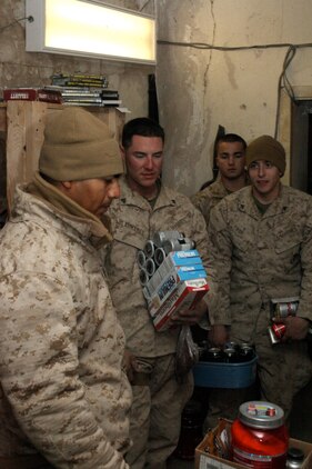 Marines with Bravo Battery, 1st Battalion, 10th Marine Regiment, 1st Marine Division (Forward), wait in line to check out at the mobile post exchange operated by Marine Corps Community Services near the Kajaki Dam, Dec. 25. MCCS and Disbursing Marines with 1st Marine Logistics Group (Forward) arrived in Kajaki on Christmas day to provide goods such as snacks and other comfort items to the Marines in the area.