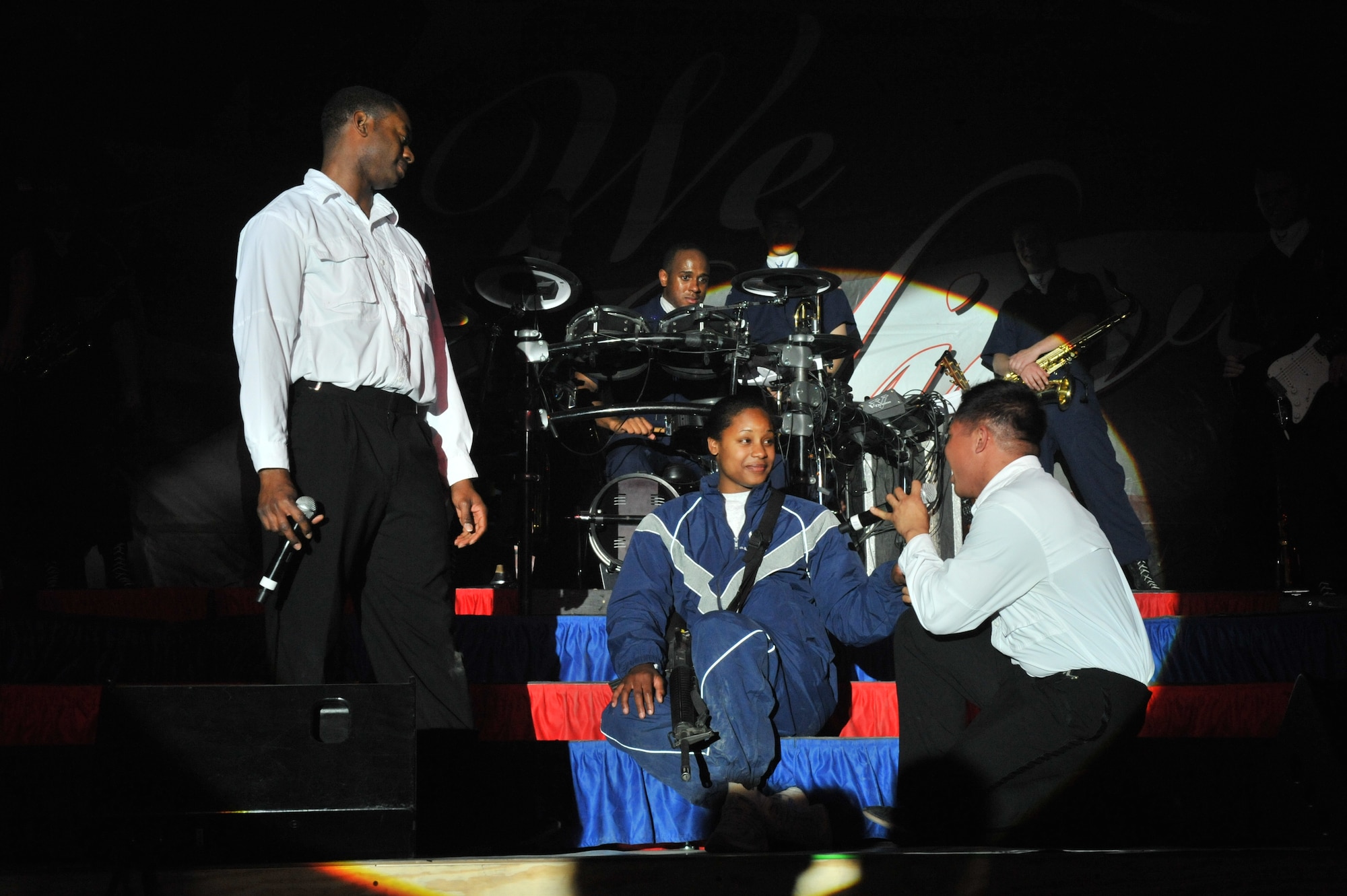 U.S. Air Force Staff Sgt. Antonio Howard and Harron Elloso, Tops in Blue vocalists, serenade Airman 1st Class Candice Griffin, 455th Expeditionary Maintenance Group weapons loader, during their performance at Bagram Airfield, Afghanistan, Dec. 24. 2010. The Tops in Blue team consists of world-class Air Force active duty talents selected to perform around the world. Airman Griffin is assigned to Seymour Johnson Air Force Base, N.C., and is a native from Baltimore, Md. (DoD photo by U.S. Air Force Senior Airman Sheila deVera/RELEASED)