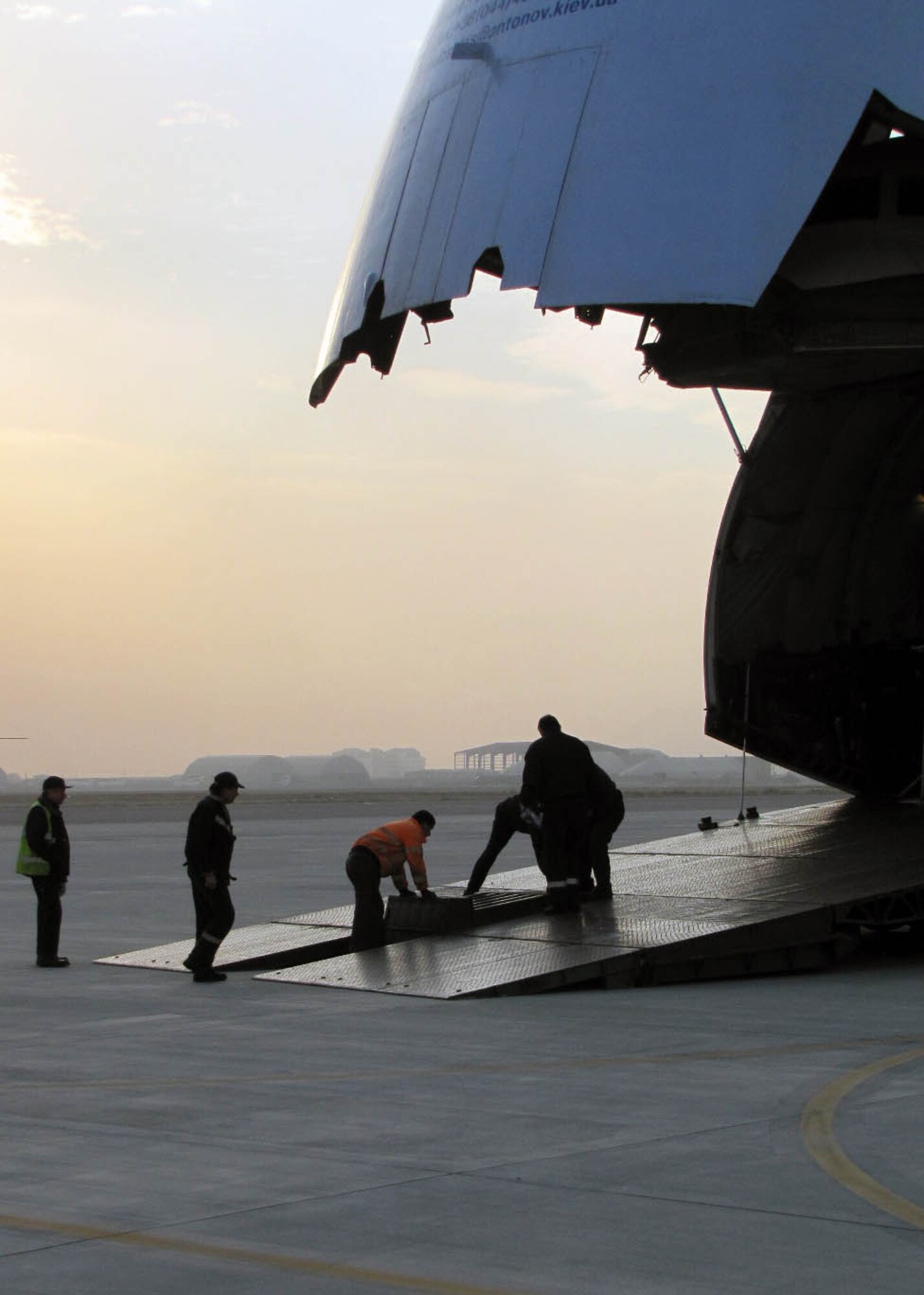 KABUL, Afghanistan -   An-124 contractors prepare for two Afghan Air Force Mi-17s transport aircraft and Mi-35 attack helicopter to be loaded onto the An-124 at the Afghan Air Force Base in Kabul, Afghanistan Dec.26. The Afghan Air Force does not have the capability yet to overhaul the aircraft so the aircraft will be shipped to the contractors facility. (U.S. Navy photo by Mass Communications Specialist 3rd Class Jared Walker/ RELEASED).