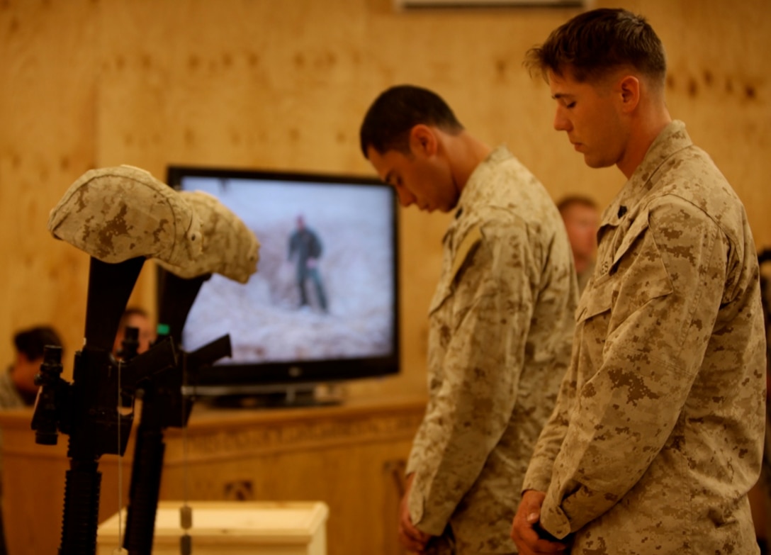 Service members pay their final respects in front of a memorial display of upturned rifles, combat boots and helmets during a memorial service for Sgt. Jason T. Smith and Gunnery Sgt. Justin E. Schmalstieg at Camp Leatherneck, Afghanistan, Dec. 26. Smith and Schmalstieg, assigned to 1st Explosive Ordnance Disposal Company, 1st Marine Logistics Group (Forward), were killed in action Nov. 19 and Dec. 15, respectively, while conducting combat operations in Helmand province, Afghanistan.