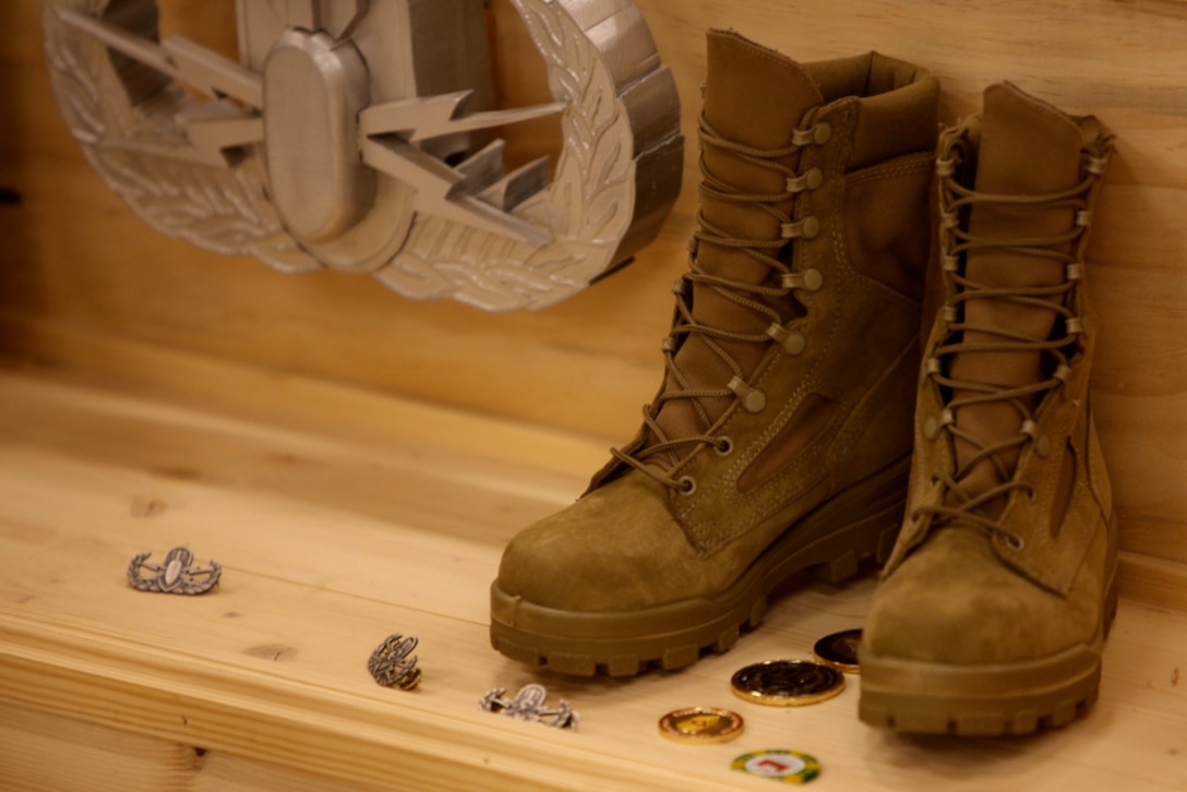 Service members pay their final respects to Sgt. Jason T. Smith and Gunnery Sgt. Justin E. Schmalstieg by leaving small tokens of gratitude for their sacrifice in front of a memorial display during a memorial service at Camp Leatherneck, Afghanistan, Dec. 26. Smith and Schmalstieg, assigned to 1st Explosive Ordnance Disposal Company, 1st Marine Logistics Group (Forward), were killed in action Nov. 19 and Dec. 15, respectively, while conducting combat operations in Helmand province, Afghanistan.