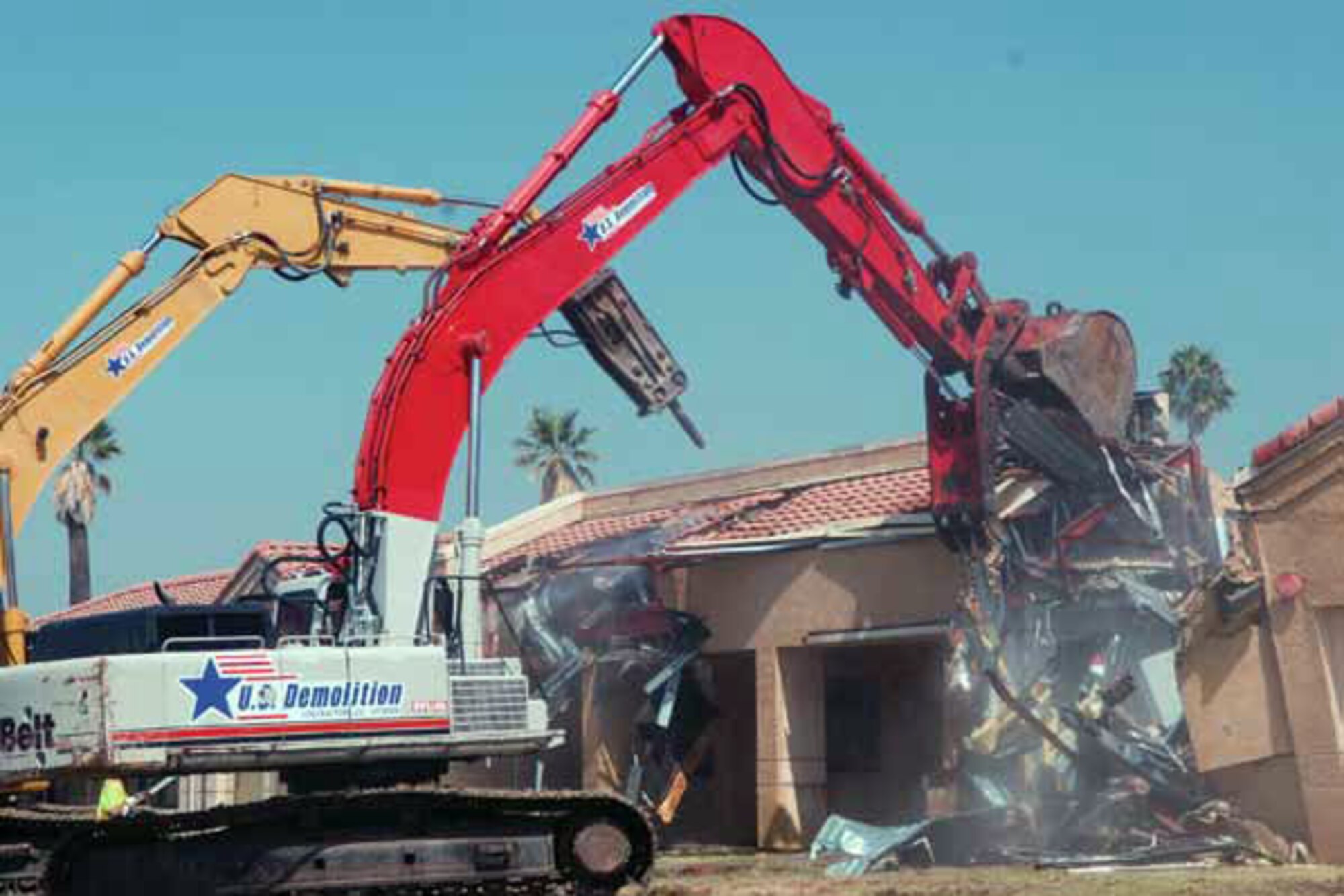 Two wrecking machines dig into the building that formerly housed the child development center at March Air Force Base. (U.S. Air Force photo by Staff Sgt. Megan Crusher)