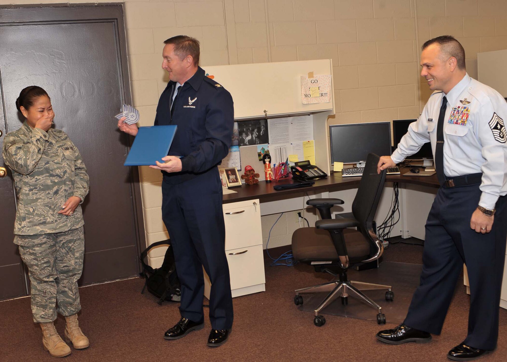 Col. Stephen Clark, 27th Special Operations Wing commander, along with Chief Master Sgt. Matthew Caruso. 27th Special Operations Wing command chief,  present Staff Sgt. Lilibeth Moeller, 27th Special Operations Logistics Readiness Squadron, with an unexpected STEP, or Stripes for Exceptional performers, promotion to technical sergeant, Dec. 27, at Cannon Air Force Base, N.M. (U.S. Air Force photo by Senior Airman James Bell)