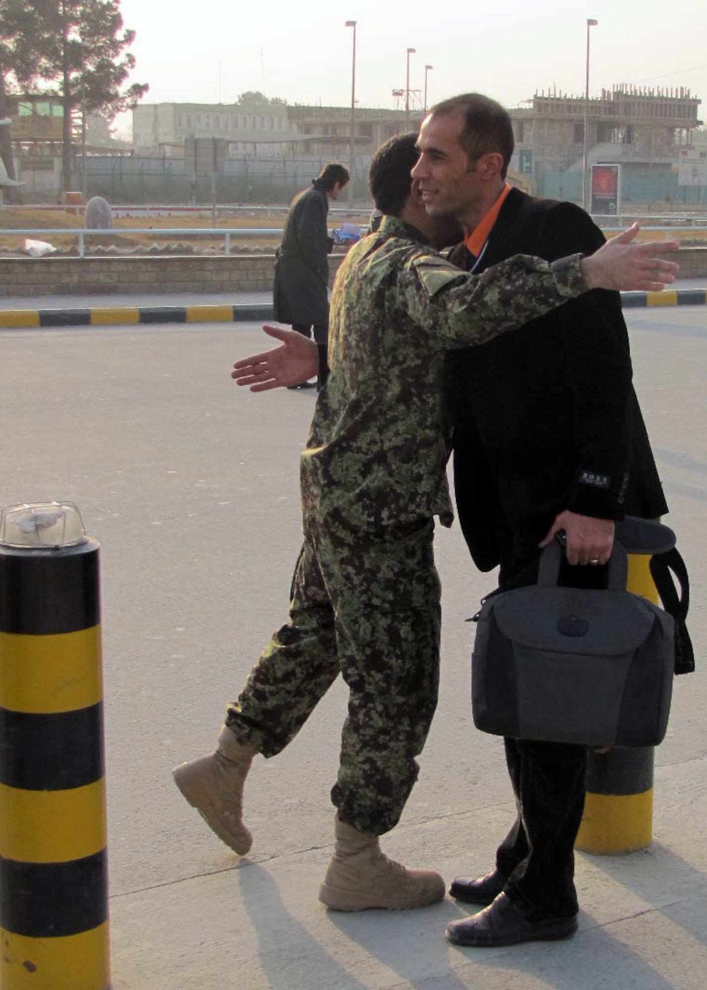 KABUL, Afghanistan -  Afghan Air Force Lieutenant Jawid Karami says good bye to one of his fellow Lieutenants from the Thunder Lab, an English immersion program at the Afghan Air Force Base in Kabul, Afghanistan, at the Kabul International Airport  Dec. 27 before he leaves for further training in America. (U.S. Navy photo by Mass Communications Specialist Third Class Petty Officer Jared Walker/ RELEASED).