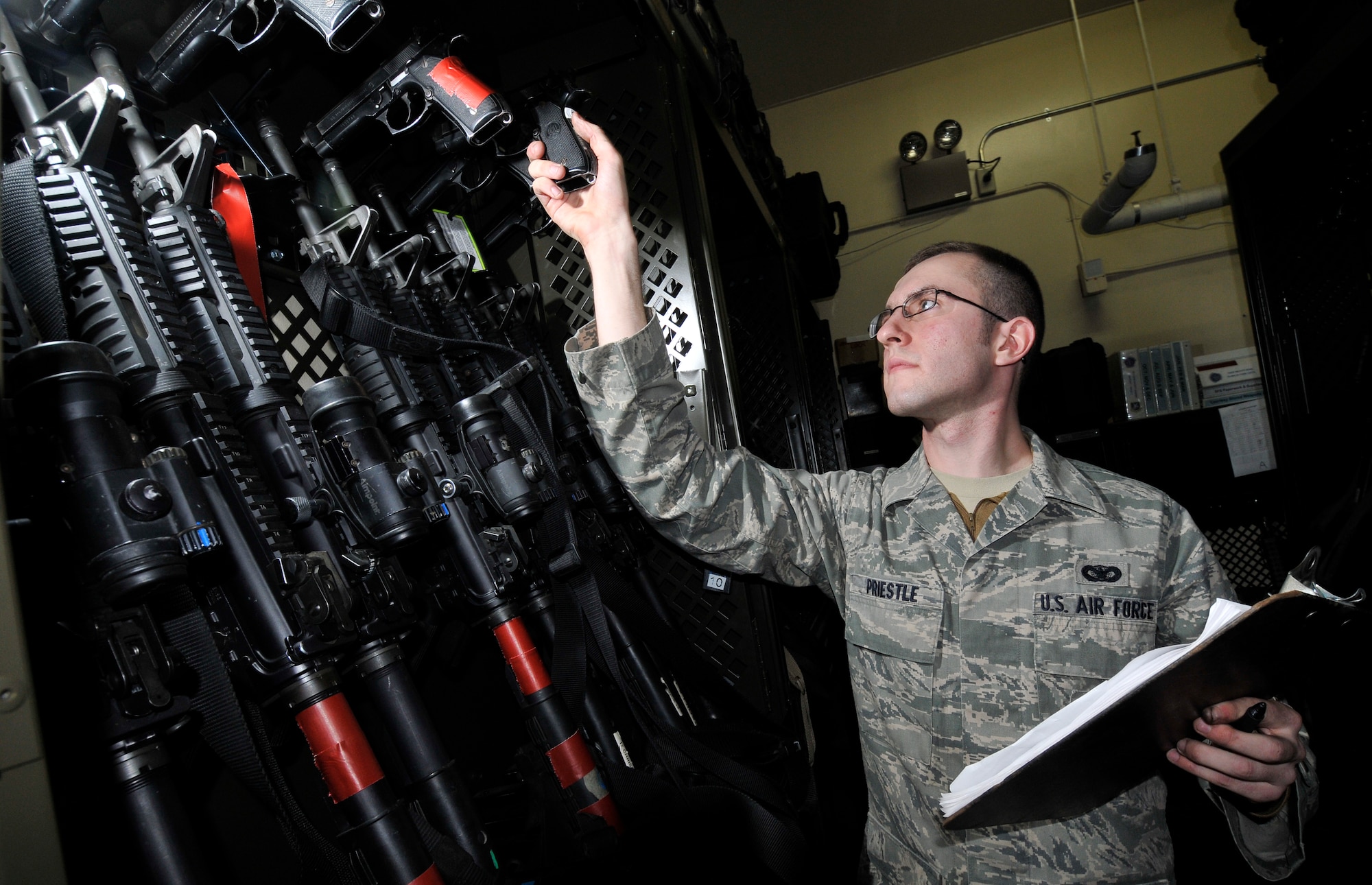 U.S. Air Force Airman 1st Class Adam Priestle, 35th Security Forces Squadron logistics armory technician, inventories M4 carbines and M9 pistols Dec. 27, 2010; Misawa Air Base, Japan. The red tape on the weapons signifies that the weapon had returned from a deployed location and combat arms training and marksmanship Airmen need to inspect them. (U.S. Air Force photo by Tech. Sgt. Phillip Butterfield/Released)  