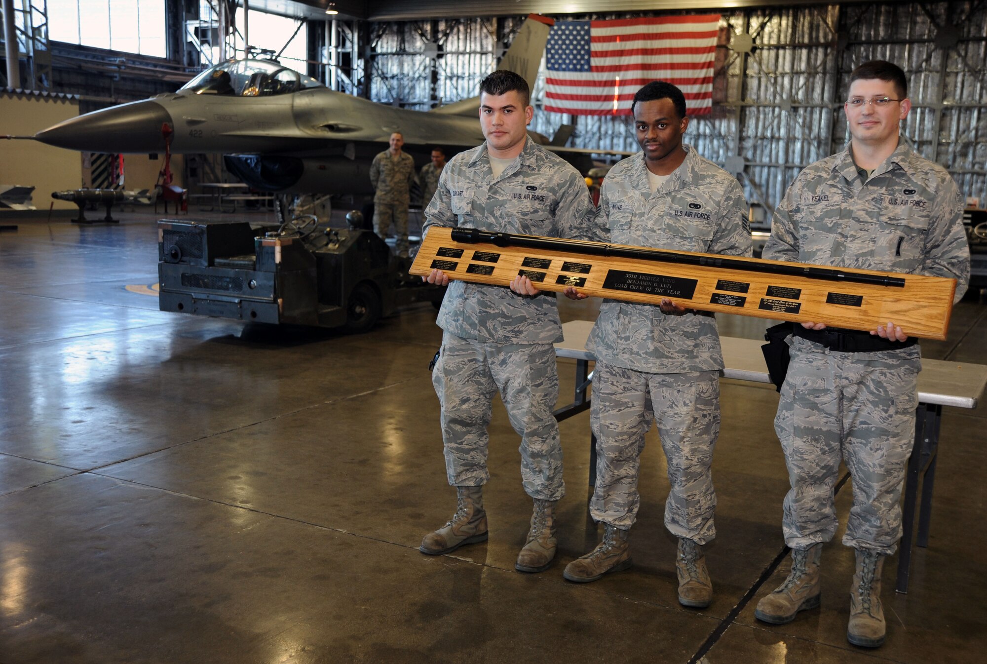(From the left) U.S. Air Force Airman, 1st Class Cassey Dukart, Staff Sgt. Rodney Akins and Staff Sgt.  Nikolai Yeakel, 35th Maintenance Squadron weapons load crew members, are the 35th Fighter Wing's load crew competition champions, scoring 1,765 points within a time of 15 minutes at Hangar 911, Misawa Air Base, Japan; Dec. 17, 2010. The winning team's score will be compared to other Pacific Air Forces bases to determine PACAF best weapons load crew.  (U.S. Air Force photo by Tech. Sgt. Russell McBride/Released)