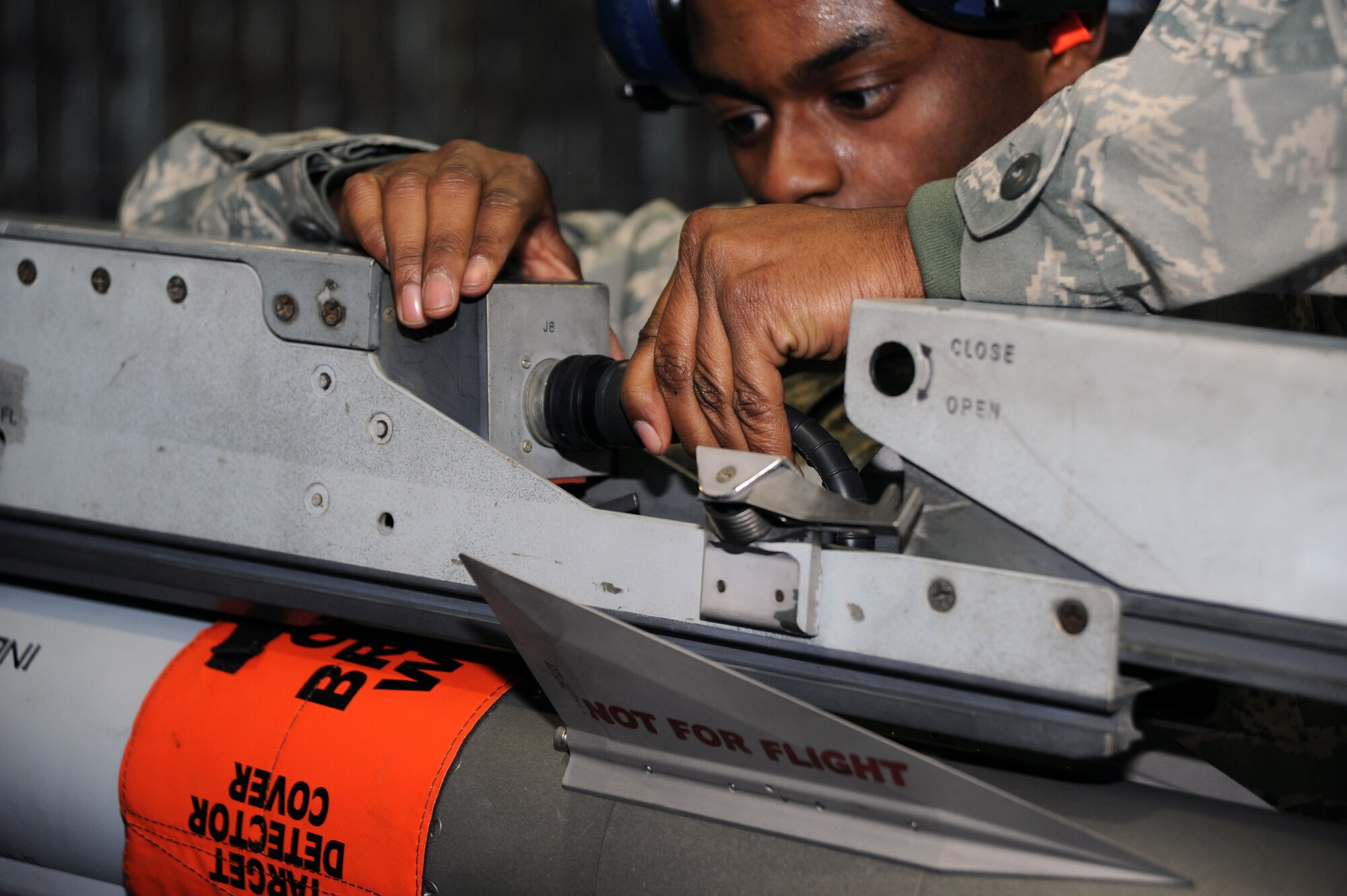 U.S. Air Force Staff Sgt. Rodney Akins, 35th Maintenance Squadron weapons load crew member, connects a umbilical cable to a missile launcher at Hangar 911, Misawa Air Base, Japan; Dec. 17, 2010. This task is one of many completed during a load crew competition. During the competition, the Airmen were graded on a variety of areas including, speed, accuracy, appearance and safety. (U.S. Air Force photo by Tech. Sgt. Russell McBride/Released)