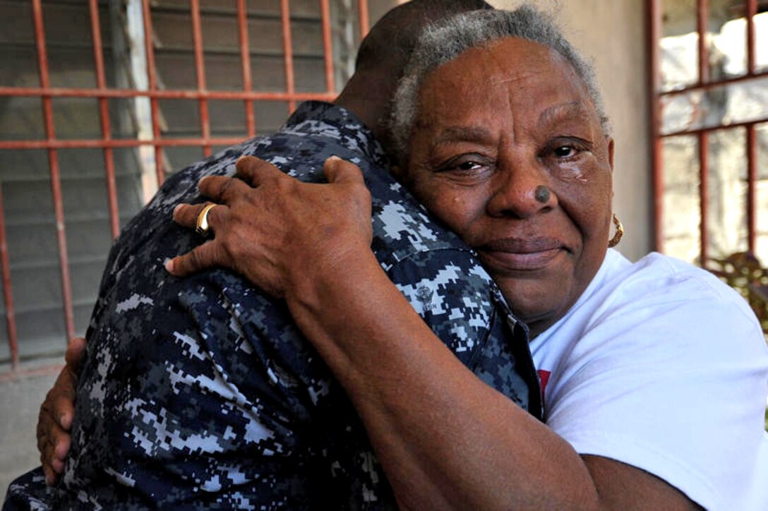 U.S. Navy Petty Officer 2nd Class Jonas Bonhomme comforts his mother after reuniting with his family in Port-au-Prince, Haiti, Feb. 7, 2010. Bonhomme was attached to the USS George H.W. Bush and assigned to the hospital ship USNS Comfort in support of relief operations in earthquake-ravaged Haiti.