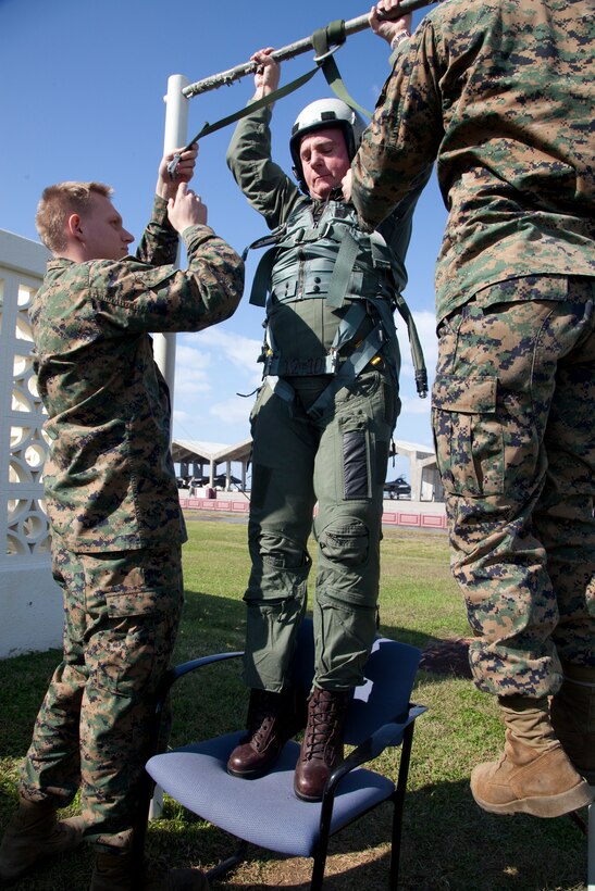 Cpl. Brian Wendely, Marine All-Weather Fighter Attack Squadron 225 flight equipment technician, performs a hang check on Lt. Gen. Terry G. Robling, former III Marine Expeditionary Force commanding general, before Robling is clear to take his final III MEF flight here Dec. 28. Hang checks are regularly conducted to ensure properlu fitted flight gear.
