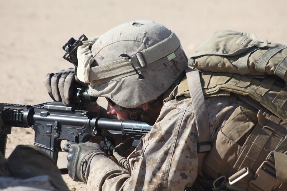 A Marine with Company L, Battalion Landing Team 3/8, 26th Marine Expeditionary Unit, uses his hand to block the sun from his Rifle Combat Optic during a battle sight zero firing exercise aboard Camp Buehring, Kuwait, Dec. 28, 2010. Elements of 26th MEU disembarked the ships of Kearsarge Amphibious Ready Group to conduct sustainment training in various Middle Eastern and African countries. (Official USMC photo by Sgt. Jesse J. Johnson/ Released) ::r::::n::