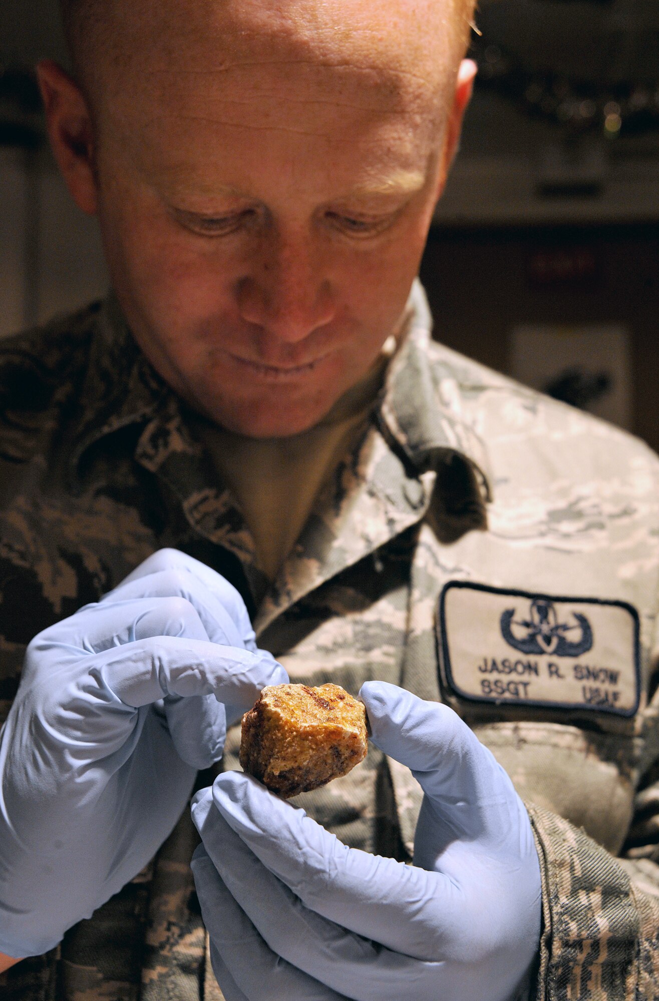 Staff Sgt. Jason Snow looks closely at an unknown substance Dec. 26, 2010, on Camp Victory, Iraq. Sergeant Snow is the NCO in charge of the Combined Explosive Exploitation Cell triage laboratory for Combined Joint Task Force Troy. CJTF Troy is dedicated to countering IEDs and saving lives of Iraqi and joint forces conducting Operation New Dawn, and one key responsibility of CJTF Troy and CEXC members is neutralizing the threat of improvised explosive devices through collection and exploitation of IED evidence and related intelligence. (U.S. Air Force photo/Senior Airman Andrew Lee)