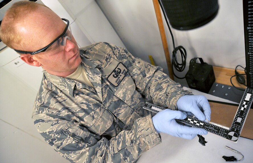 Staff Sgt. Jason Snow holds a blasting cap beside a ruler to photograph the measurements Dec. 26, 2010, on Camp Victory, Iraq. Sergeant Snow is the NCO in charge of the Combined Explosive Exploitation Cell triage laboratory for Combined Joint Task Force Troy. CJTF Troy is dedicated to countering IEDs and saving lives of Iraqi and joint forces conducting Operation New Dawn, and one key responsibility of CJTF Troy and CEXC members is neutralizing the threat of improvised explosive devices through collection and exploitation of IED evidence and related intelligence. (U.S. Air Force photo/Senior Airman Andrew Lee)
