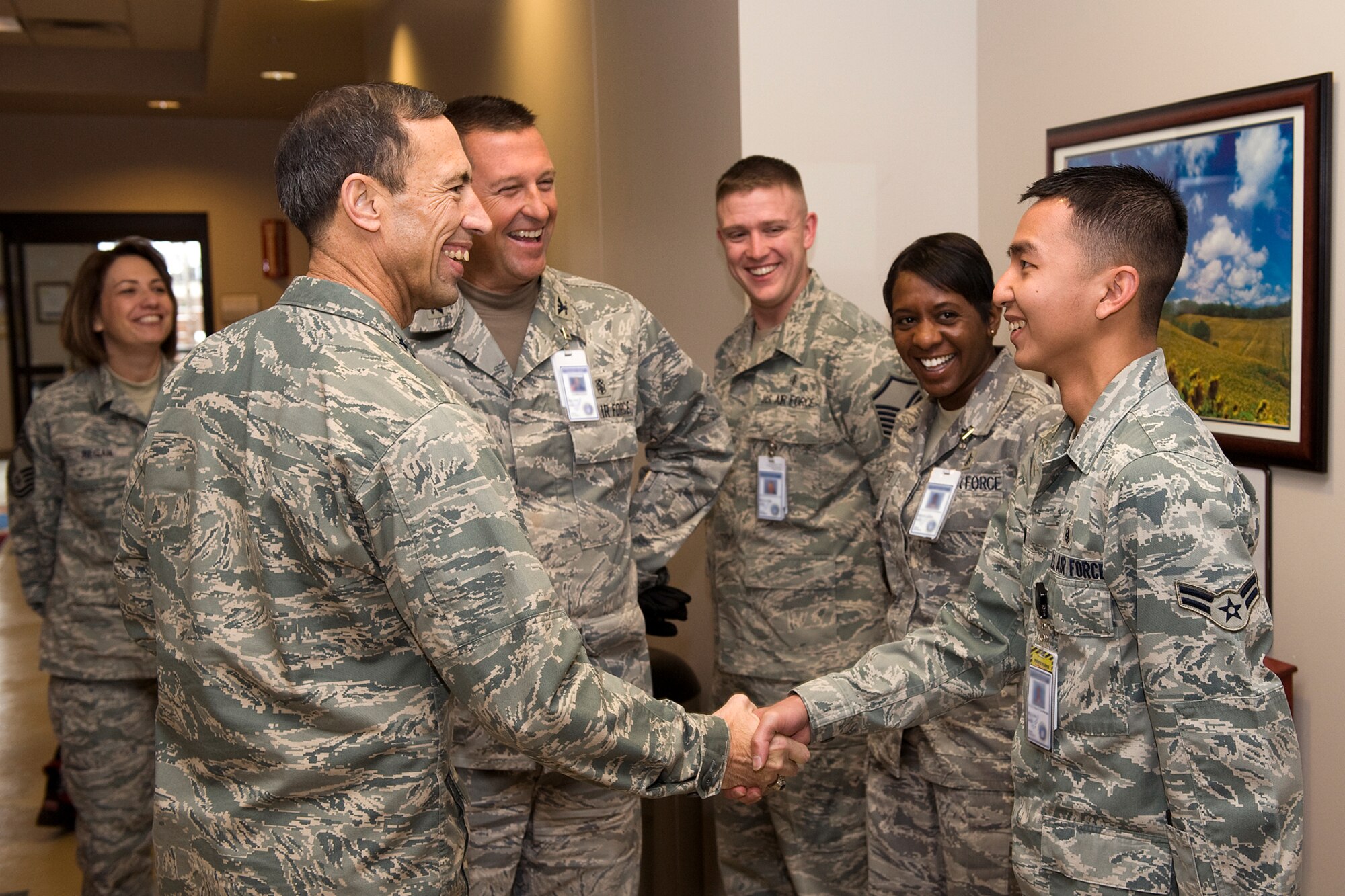 Lt. Gen. Larry D. James, 14th Air Force commander (left) congratulates Airman 1st Class Kyaw Minn, 21st Medical Group, Public Health technician (right) after Col. John Sell, 21st Medical Group commander (left rear) announced that Airman Minn has been promoted to senior airman below the zone. The 21st MDG was just one of many stops General James made during a tour of Peterson Air Force Base Dec. 17. General James will relinquish command of the 14th AF in January for his new assignment as deputy chief of staff, Intelligence, Surveillance and Reconnaissance, Headquarters U.S. Air Force, at the Pentagon. (U.S. Air Force photo/Craig Denton) 