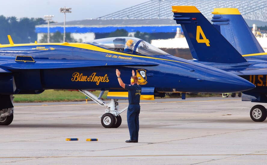 A Blue Angels crew chief marshals his F/A-18 Hornet to its parking spot on the Dobbins Air Reserve Base ramp Oct. 14.  The Blue Angels will fly their exciting demonstration during the Wings Over Atlanta 2010 Air Show.  (U.S. Air Force photo/ Brad Fallin)