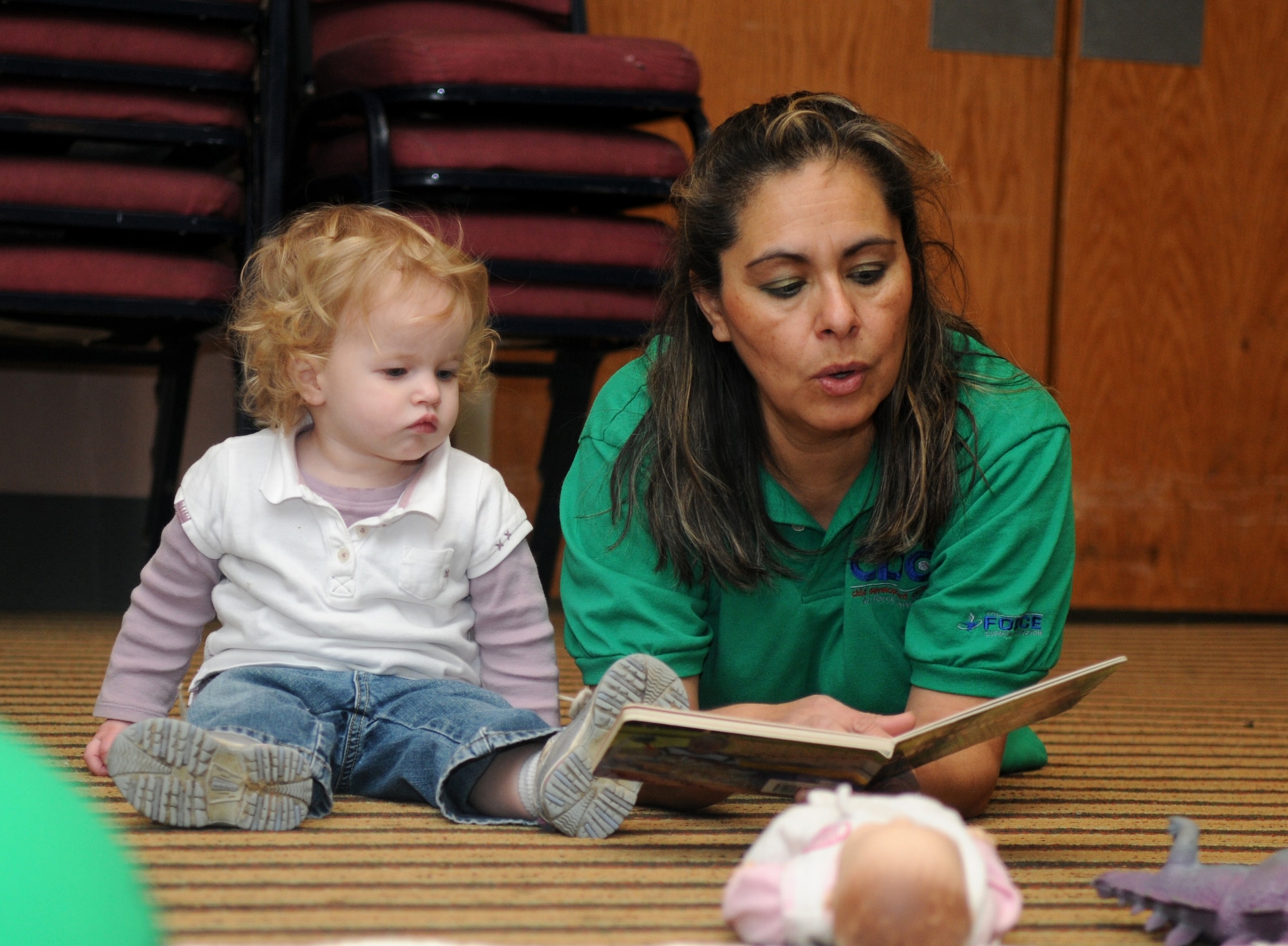 GOODFELLOW AFB, Texas - Carmen Trufant, care provider at the Child Development Center, reads a book to Adalia Hough during an exercise at Goodfellow AFB, TX, 22 Dec.  The CDC held an evacuation exercise taking the children to an alternate location for care to ensure proficiency in emergency procedures. (U.S. Air Force photo/Staff Sgt. Heather Rodgers)
