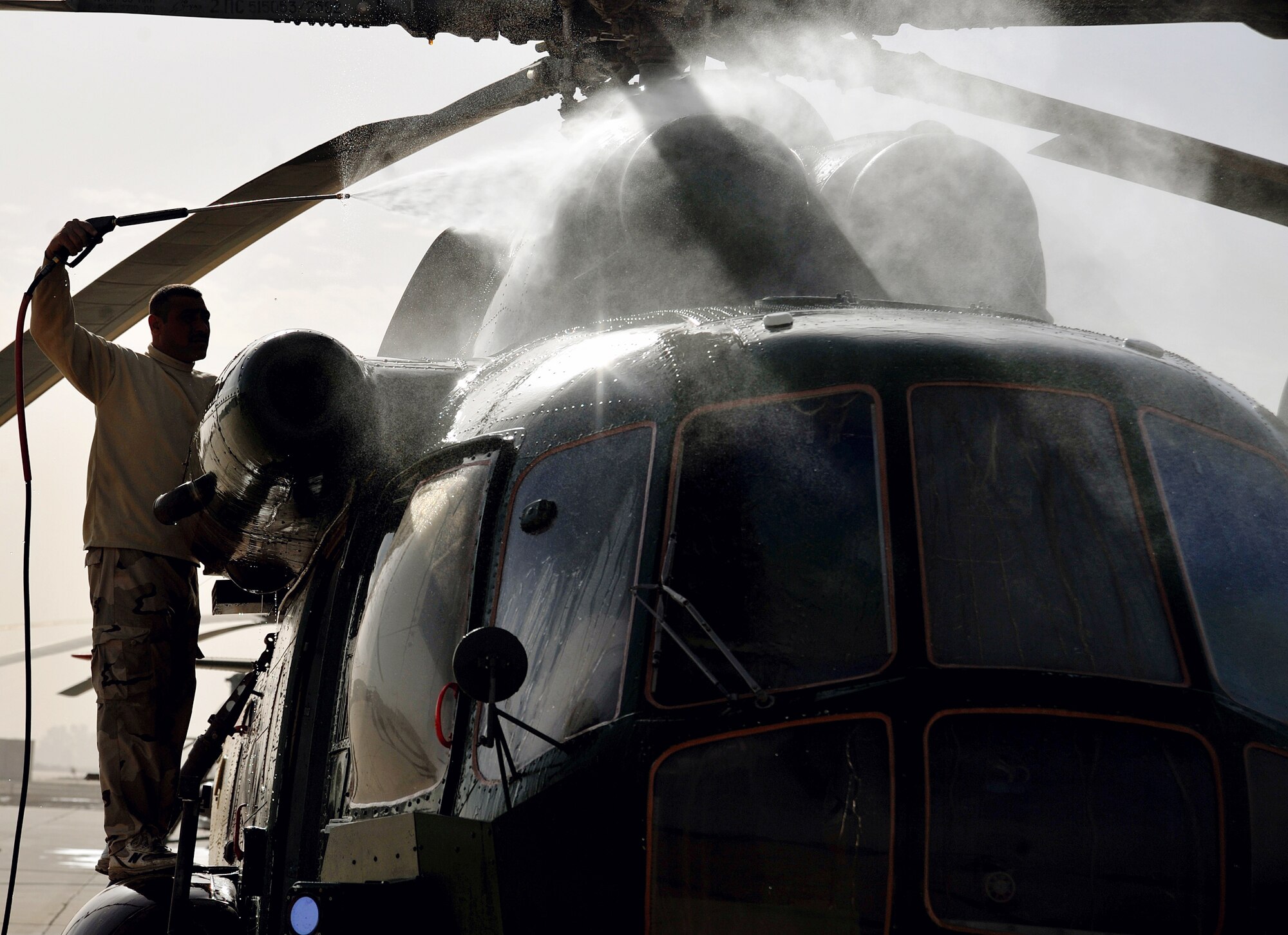 An Iraqi Army Aviation Command soldier washes the dirt off of an Mi-17 helicopter Dec. 11, 2010, on the flightline in Taji, Iraq. Air advisers with the 721st AEAS work with AAC members at Taji to advise and assist them in building a safe, self-sustaining Iraqi rotary-wing force. (U.S. Air Force photo/Senior Airman Andrew Lee)