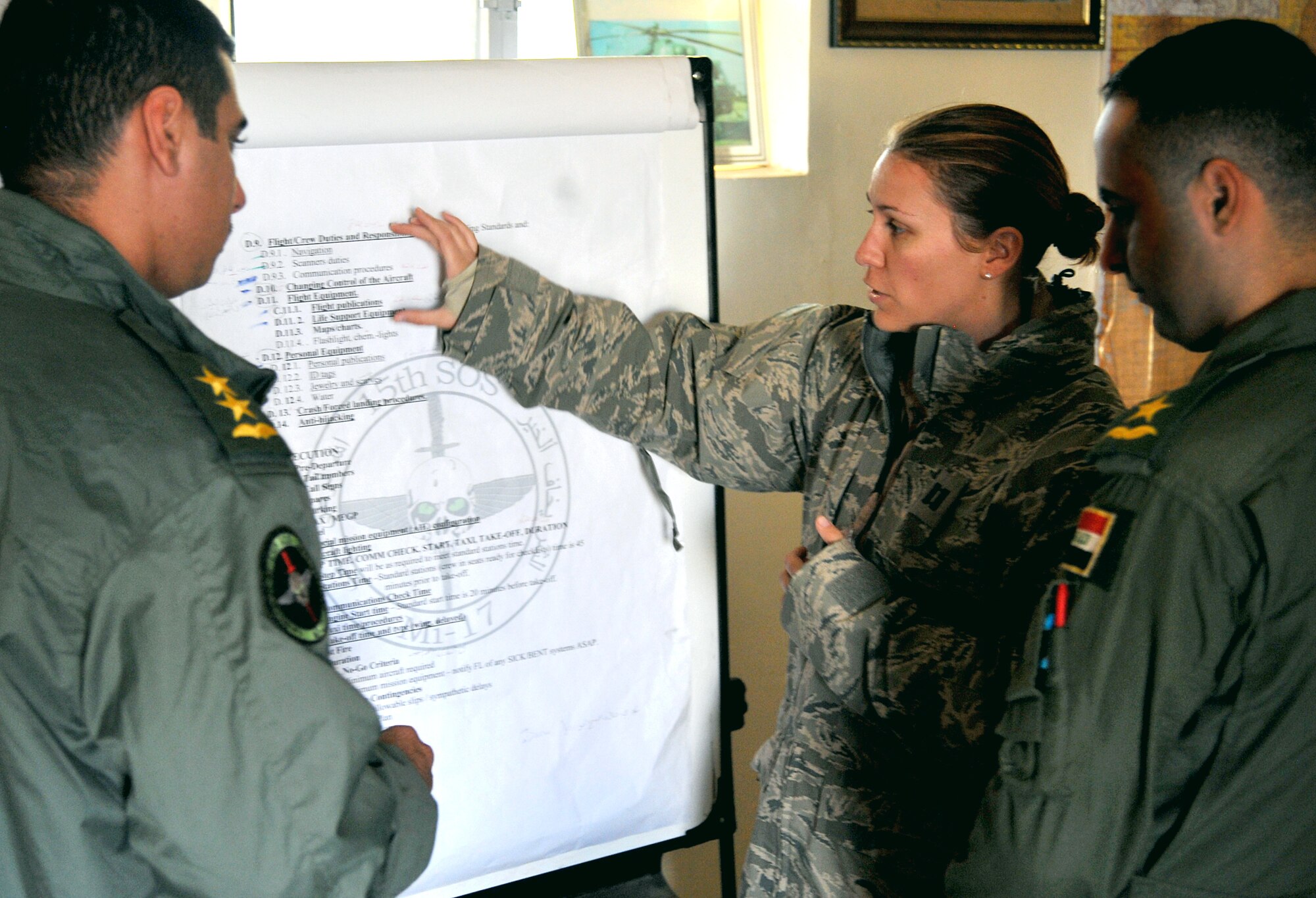 Capt. Kate DenDekker gives instructions to two Iraqi Army Aviation Command pilots during a pre-flight mission brief Dec. 12, 2010, in Taji, Iraq. Captain DenDekker is a combat air adviser with the 721st Air Expeditionary Advisory Squadron. Air advisers from the 721st AEAS instruct and advise AAC pilots to help build a safe, self-sustaining Iraqi rotary-wing force. (U.S. Air Force photo/Senior Airman Andrew Lee)