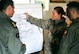 Capt. Kate DenDekker gives instructions to two Iraqi Army Aviation Command pilots during a pre-flight mission brief Dec. 12, 2010, in Taji, Iraq. Captain DenDekker is a combat air adviser with the 721st Air Expeditionary Advisory Squadron. Air advisers from the 721st AEAS instruct and advise AAC pilots to help build a safe, self-sustaining Iraqi rotary-wing force. (U.S. Air Force photo/Senior Airman Andrew Lee)