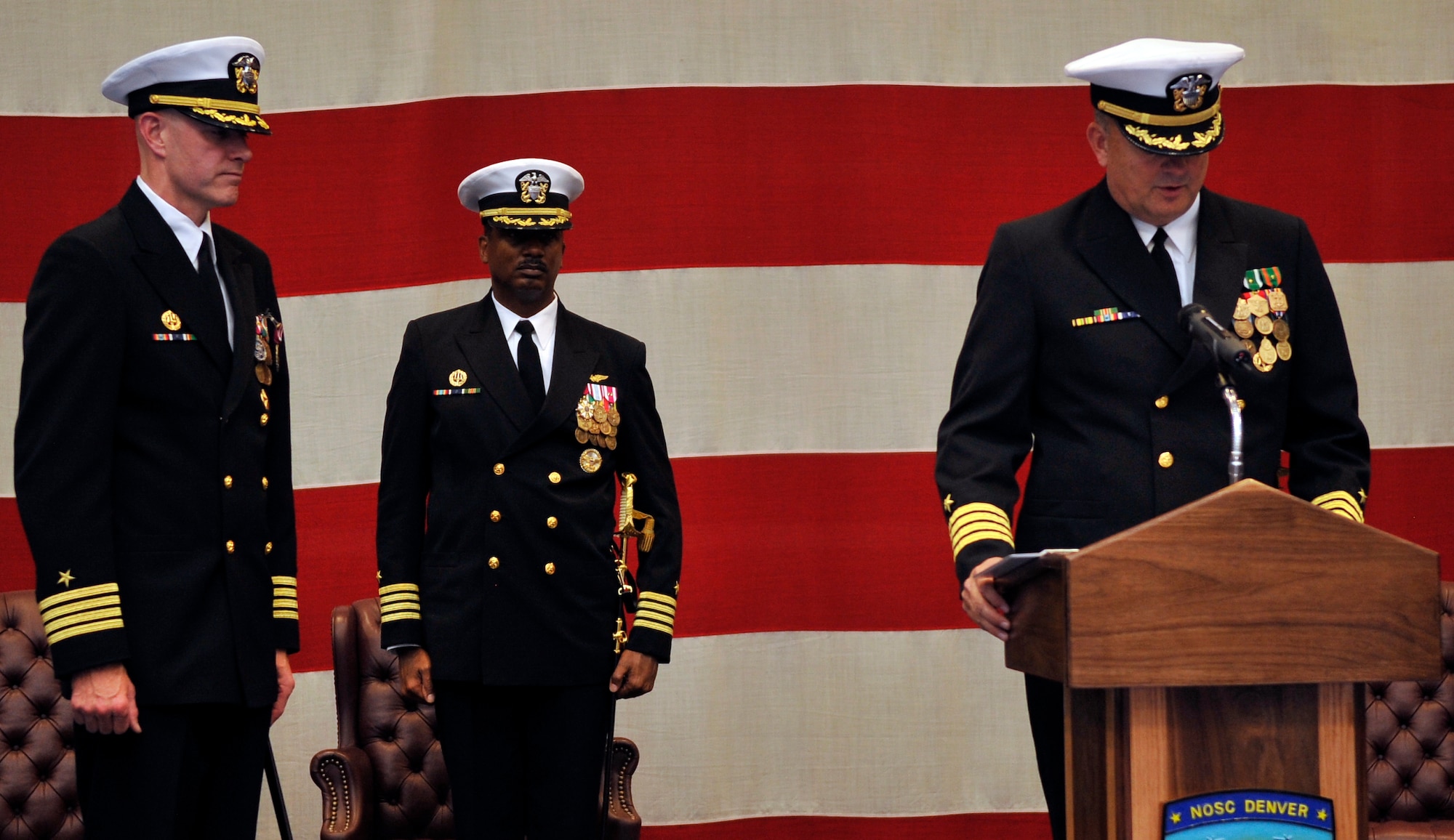 BUCKLEY AIR FORCE BASE, Colo. -- Capt. Leith Wimmer reads the orders as Capt. Shawn Grenier,former Commanding officer of Navy Operational support Center Denver and Capt. Marco Cromartie,Commanding Officer Navy Region Southwest Reserve Component Command stand at attention on Dec. 15,2010.(U.S. Air Force photo by Airman 1st Class Paul Labbe.)
