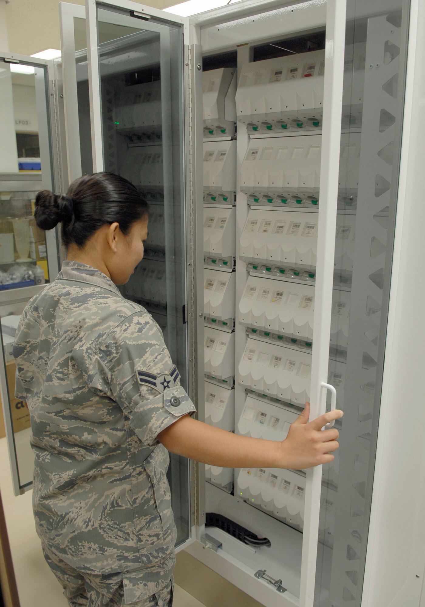 Airman 1st Class Roma Terry reviews the different types of medication the PharmASSIST ROBOTx is stocked with Dec. 10, 2010, at Kadena Air Base, Japan. The PharmASSIST can store anywhere from 70  to 140 prescription dispensers at one time based on pharmacy volume, budget and requirements. Airman Terry is a pharmacy technician with the 18th Medical Support Squadron. (U.S. Air Force photo/Airman 1st Class Tara A. Williamson)
